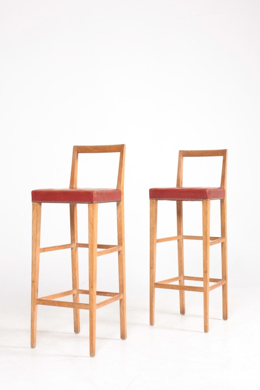 Pair of great looking bar stools in solid oak and patinated leather. Made by a Danish cabinetmaker in 1950s.