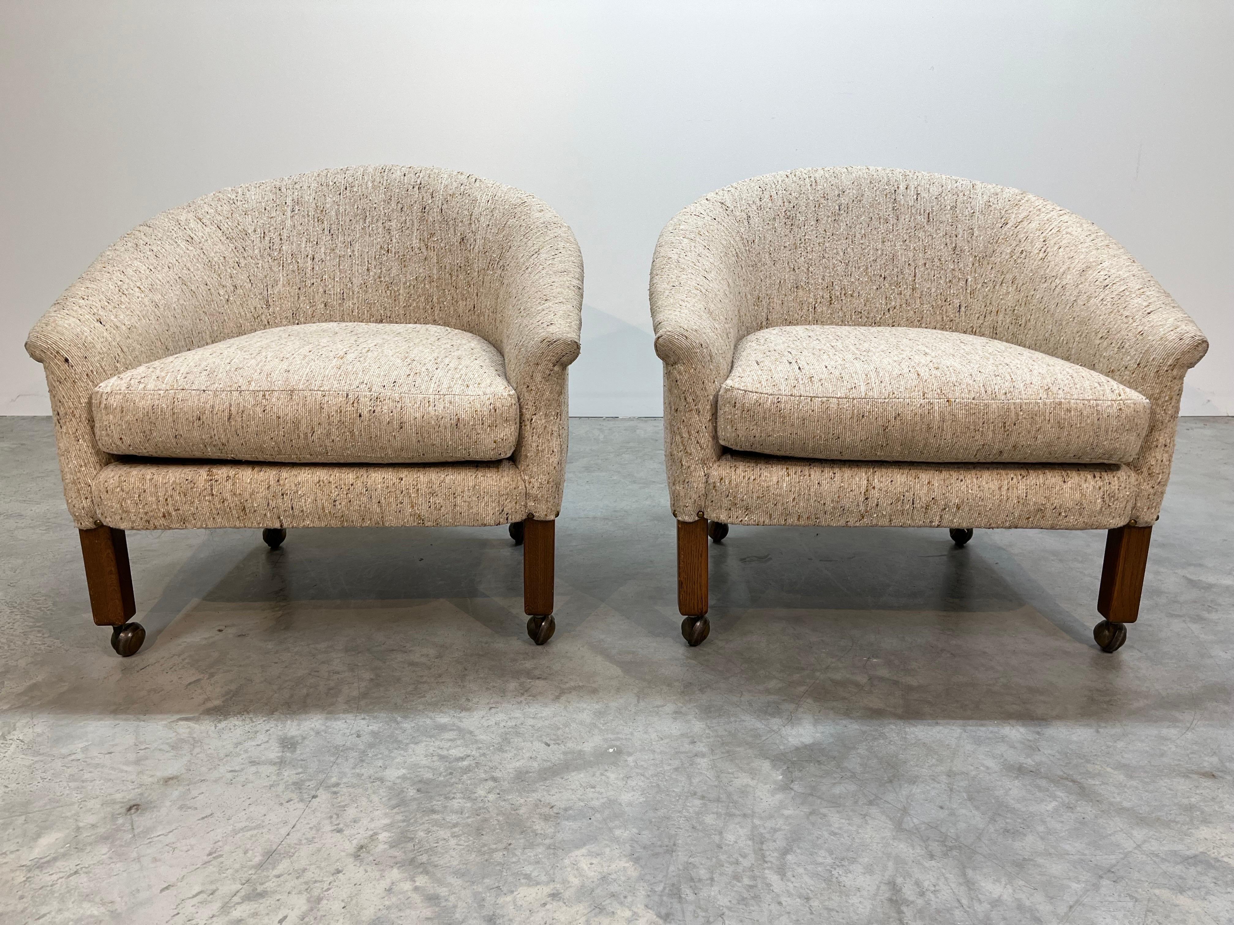 A wonderful pair of mid-century barrel back club chairs having beautiful tweed upholstery over mahogany legs with casters. Produced by Flexsteel circa 1960 and in outstanding original condition. The chairs feature the classic Flexsteel steel