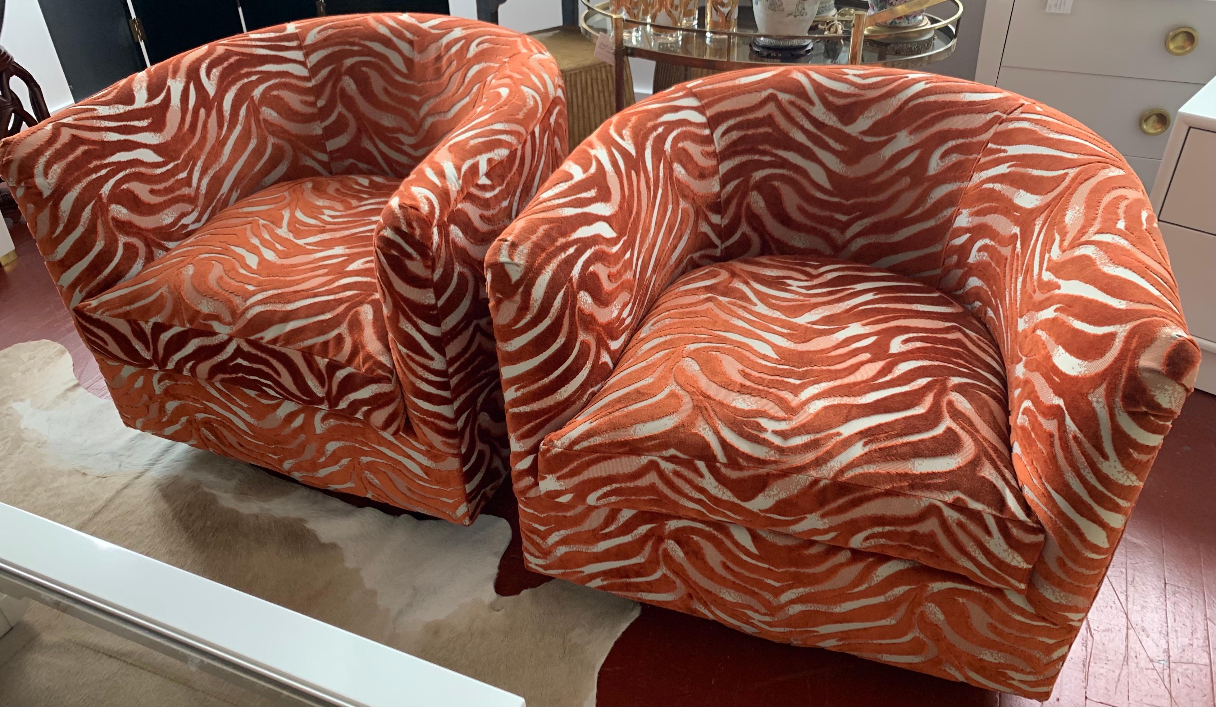 This pair of newly upholstered barrel back midcentury swivel chairs have a luxurious fabric
that is sure to set your home apart. The colors are best described as a subtle burnt orange and white
cotton fabric that almost looks and feels like a