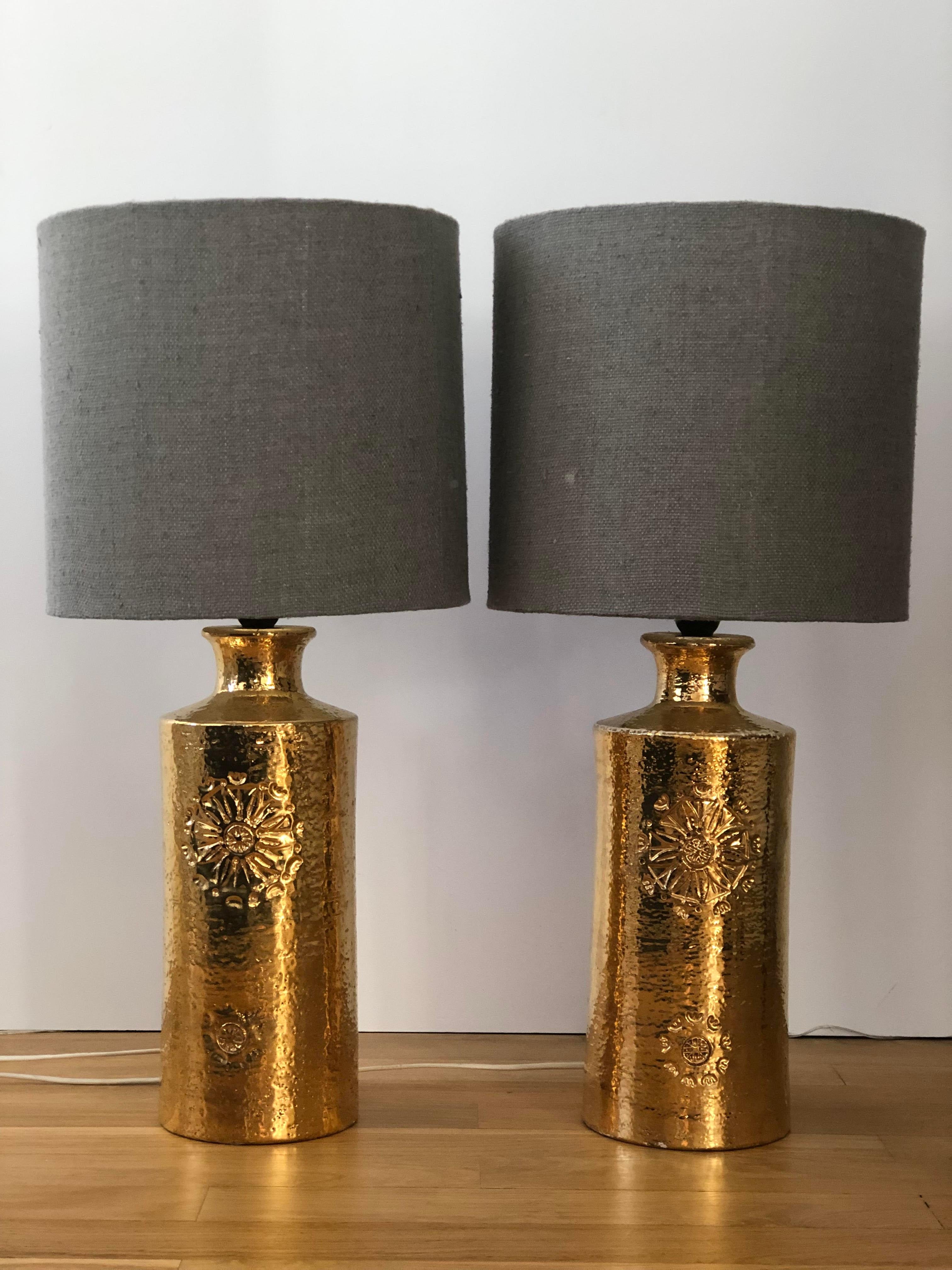 Paire de lampes de table dorées conçues par Aldo Londi pour Bitossi, Italie et fabriquées par Bergboms, Suède. Fabriqué en céramique, émaillé or, avec une fleur incisée à la main sur le devant.
Design/One moderne du milieu du siècle, production