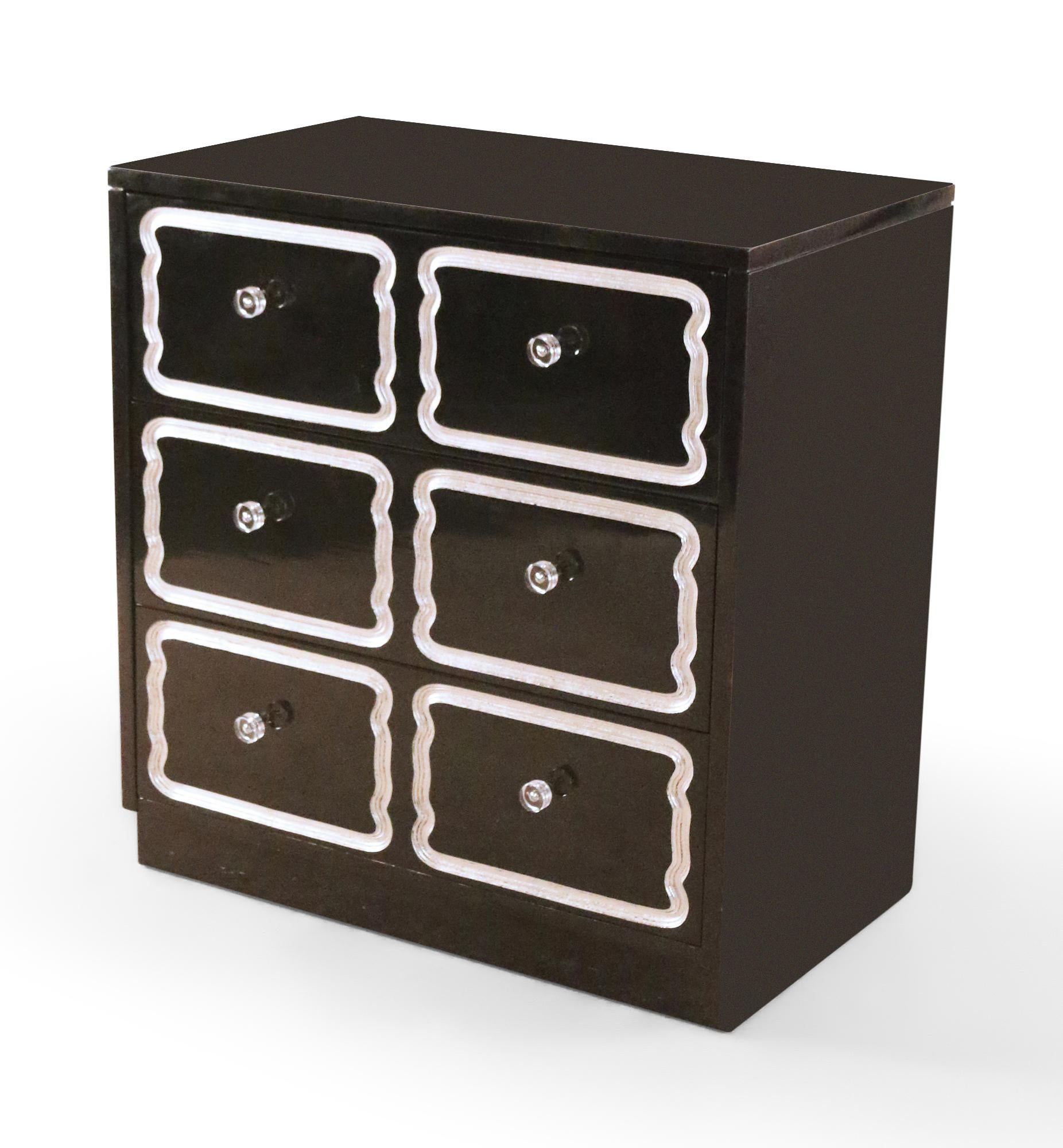 Coppia di cassettiere di metà secolo con finitura laccata nera, dettagli decorativi in lucite in rilievo, tiretti in lucite e piani in vetro nero. (PREZZO A COPPIA)

Una cassettiera non ha il pannello superiore in vetro