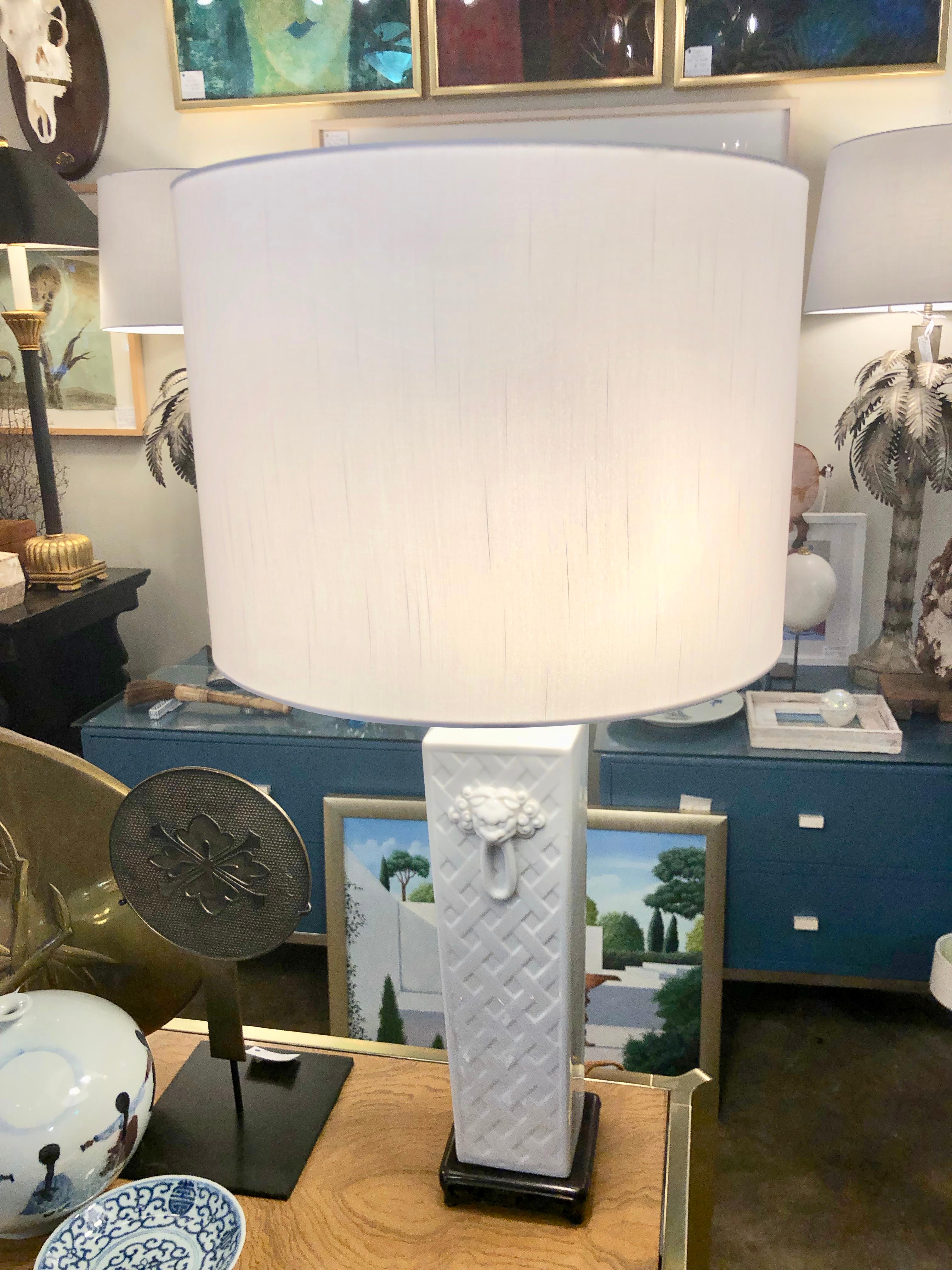 A pair of midcentury Blanc de Chine table lamps having lions head decorations with cross-hatch design.