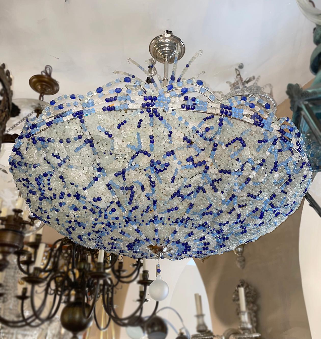 A pair of circa 1950's French blue beaded chandeliers with eight interior lights. Sold individually.

Measurements:
Height: 38.5