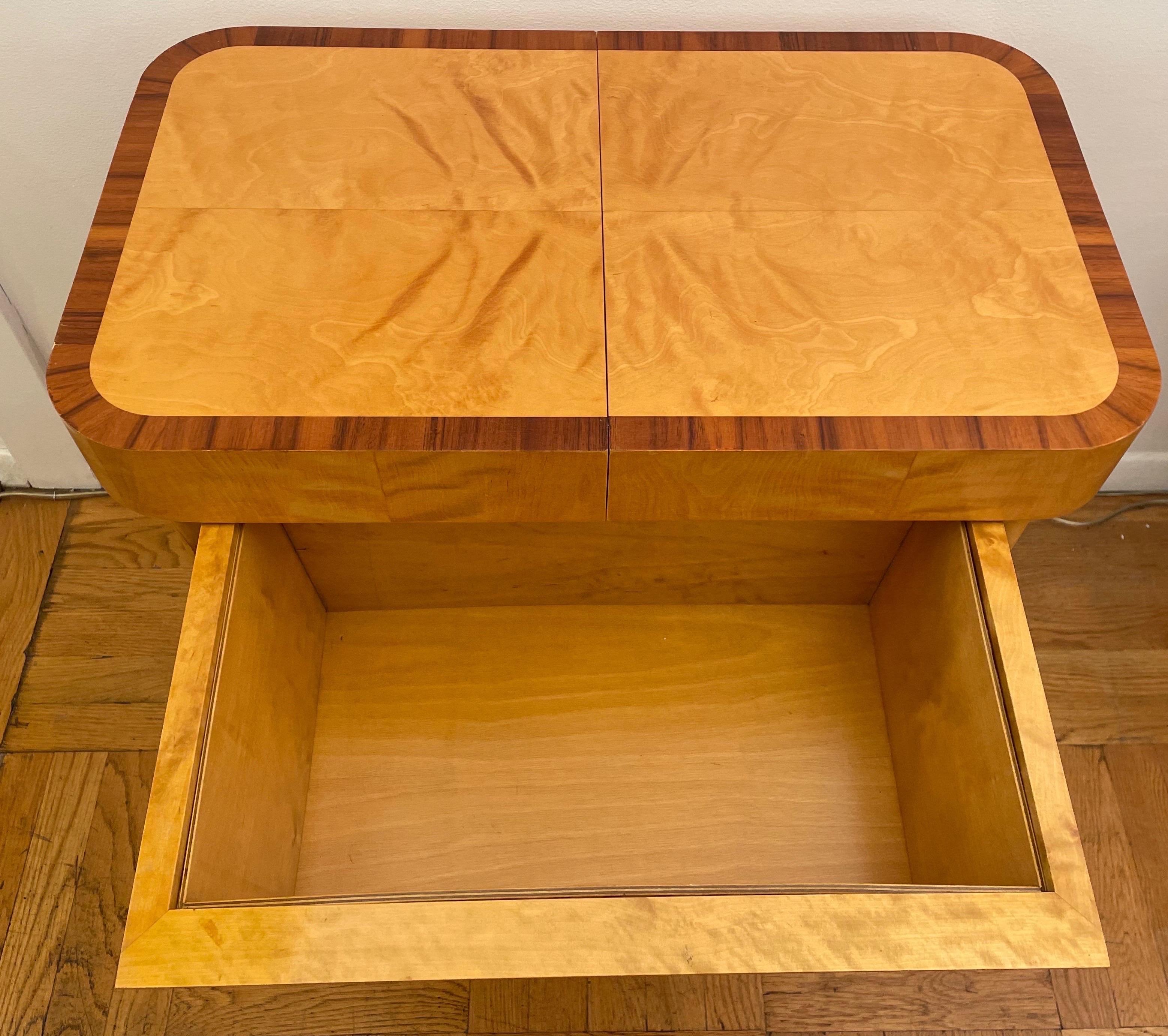 This pair of bodafors tables are made of solid swedish birch and inlayed simple mahogany details. Discreet basket style storage is hidden underneath masked by decorative bars. Additional secret compartments in the center-opening table top.