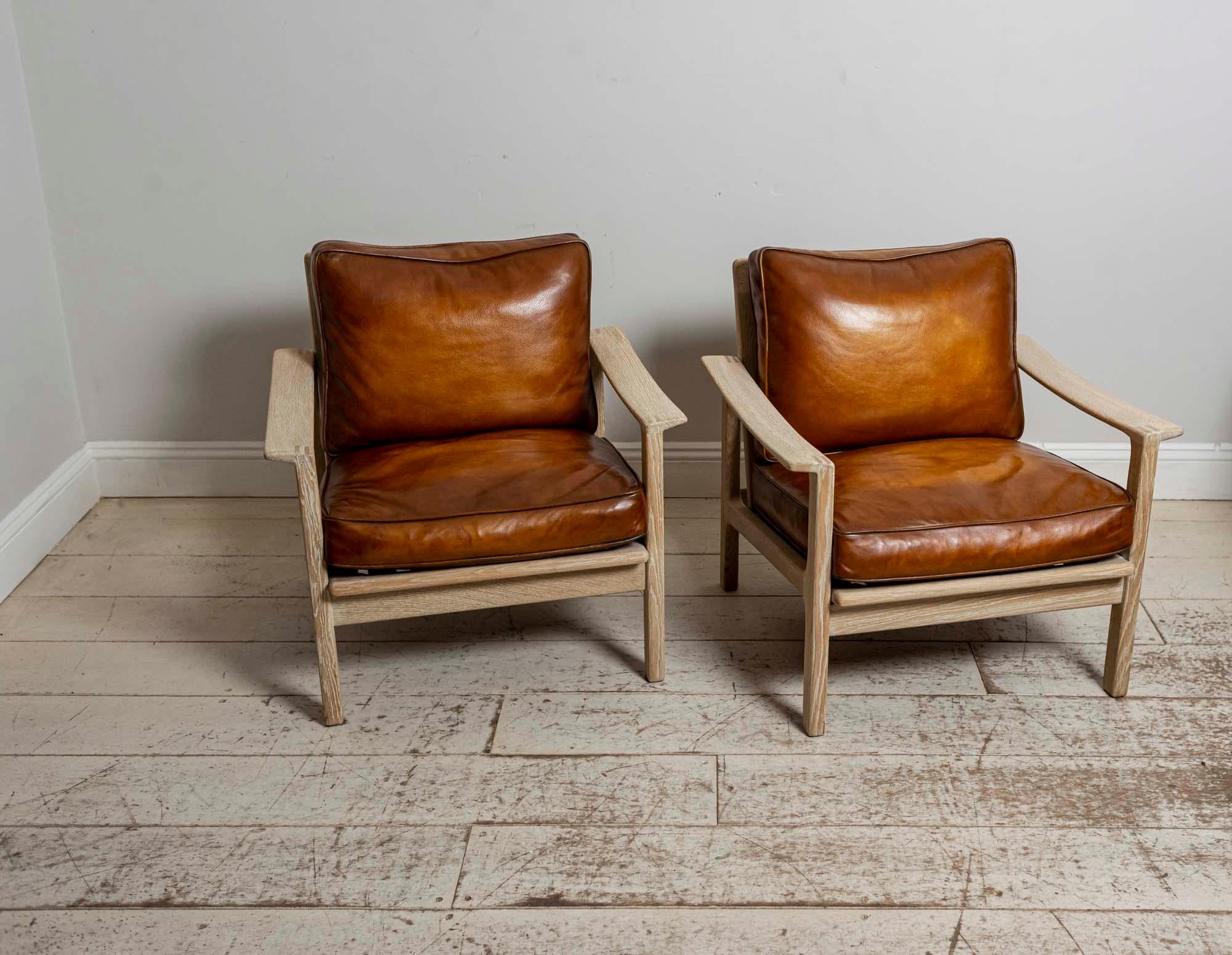 A pair of wonderful and handsome midcentury Børge Mogensen slatted backed bleached oak armchairs with deep leather cushions which have been reupholstered in a warm mid-tan leather.
A substantial, well-made and comfortable pair of armchairs which