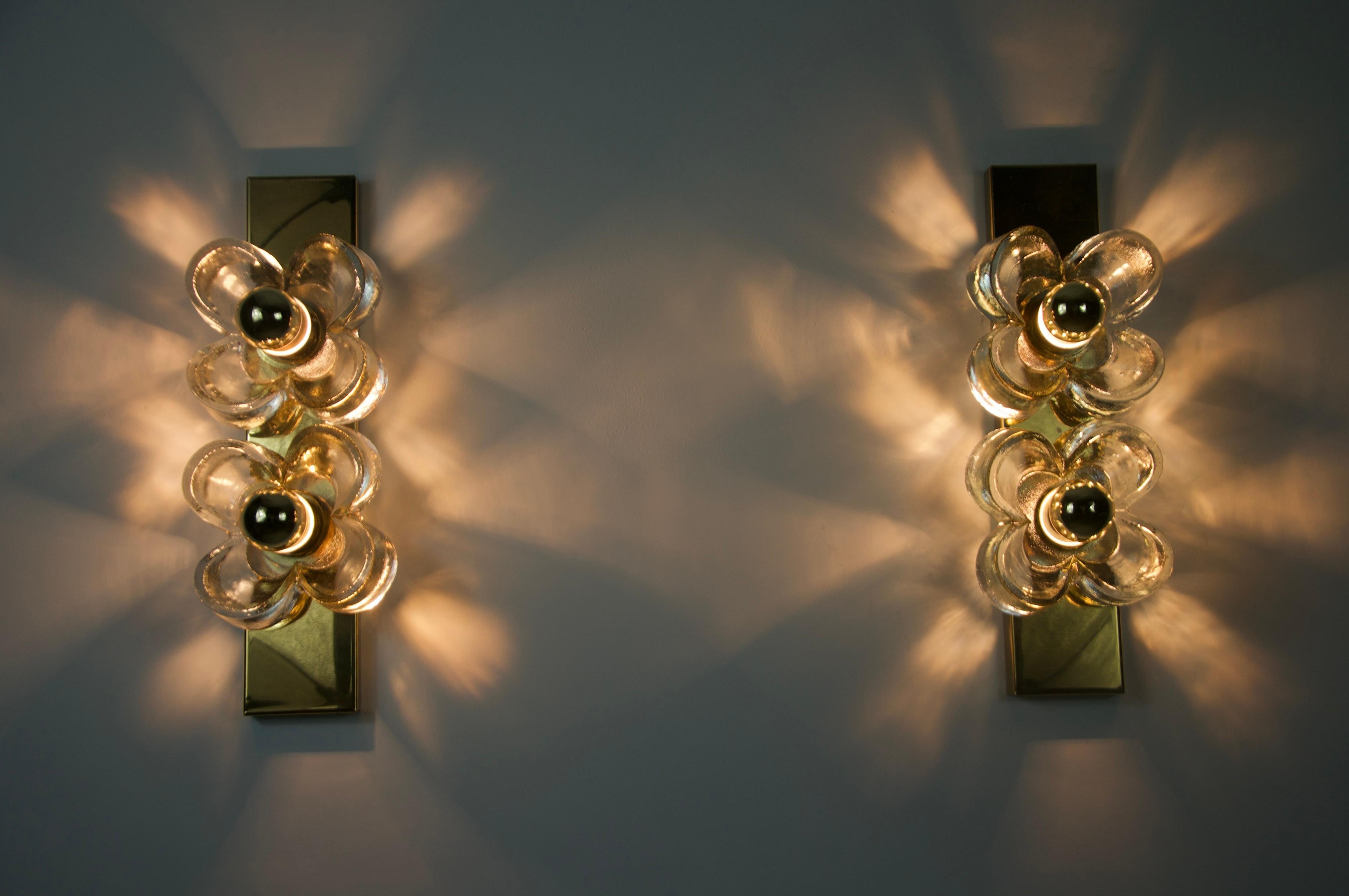 This stylish pair of wall lamps from 1960s Germany captures the essence of Mid-Century modern design with their bold geometric forms and contrasting color palette. Each sconce features a sleek, shield-shaped backplate in a combination of matte blue