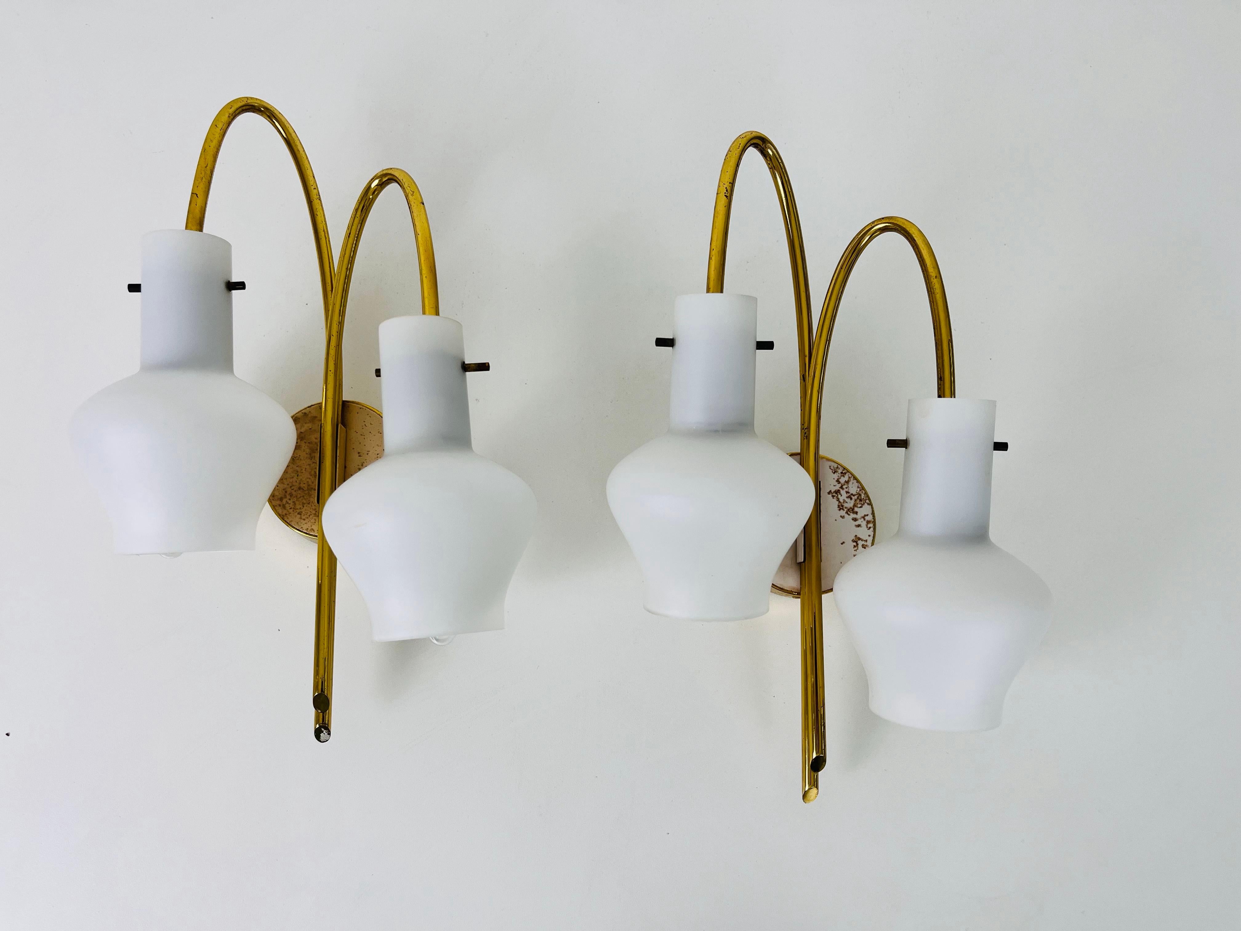 A pair of Italian Stilnovo style wall lamps made in the 1960s. It is fascinating with its rare opaline glass shade. The body of the lamp is made of brass 

The lights require E14 light bulbs. Works with both 120/220V. Very good vintage