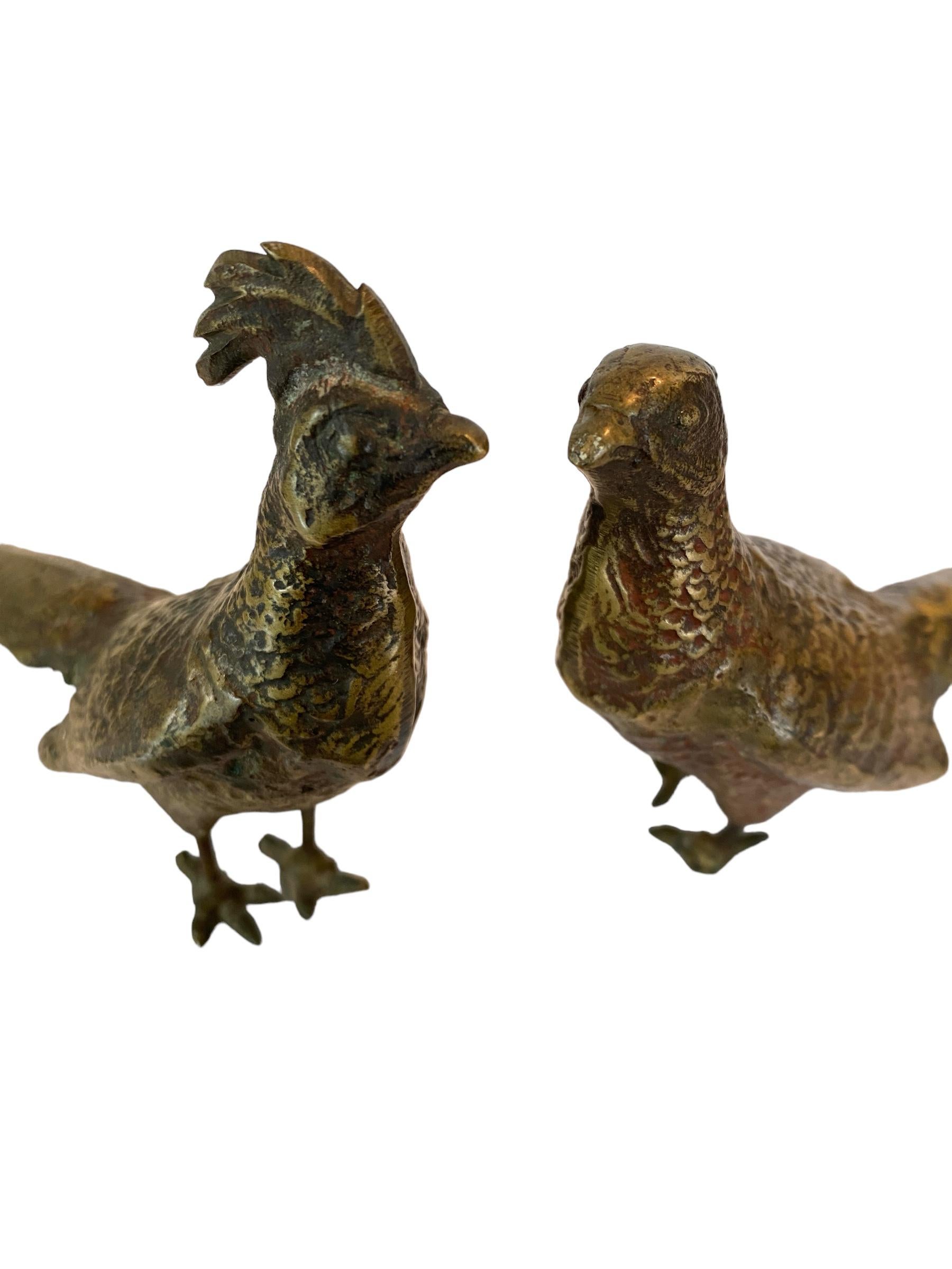 Wir präsentieren ein fesselndes Paar massiver Messinghühner aus der Jahrhundertmitte, ein Duo, das den Charme und die Eleganz dieser Epoche perfekt verkörpert. Dieses Set besteht aus einem majestätischen Hahn und einer anmutigen Henne, die beide