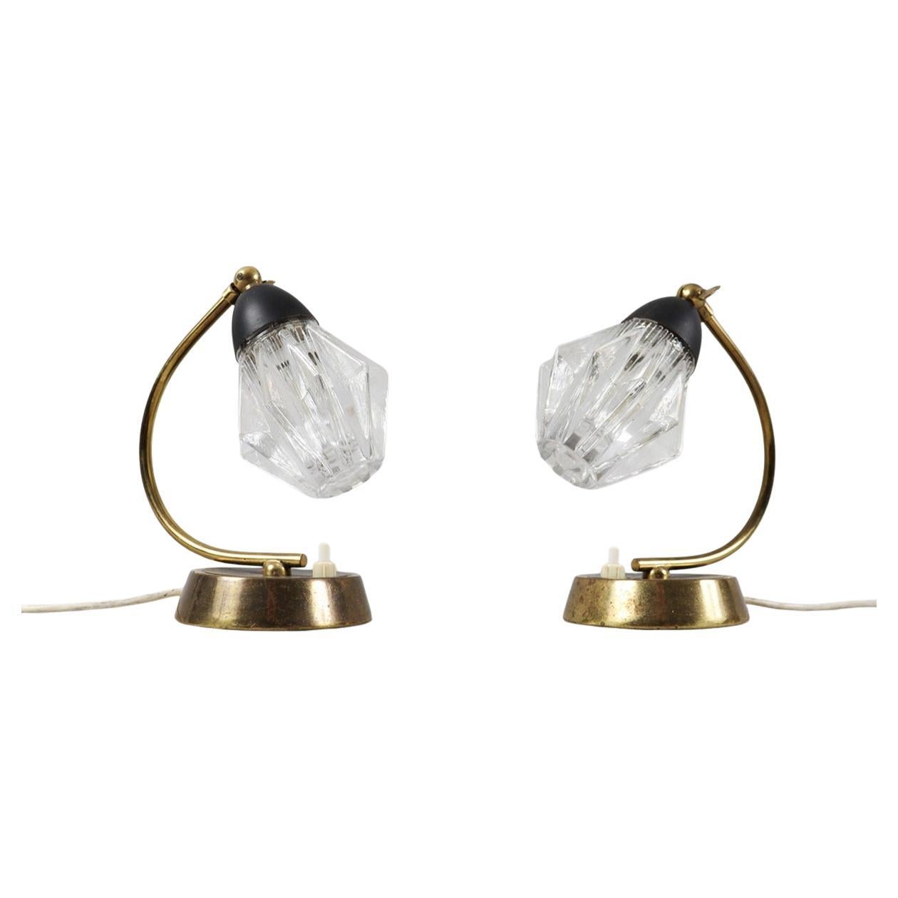 Pareja de lámparas de mesilla de noche vintage de mediados de siglo, procedentes de Alemania, hacia 1960. Cada lámpara tiene una base de latón macizo con una hermosa pátina natural y pantallas de cristal originales, que crean una luz cálida y