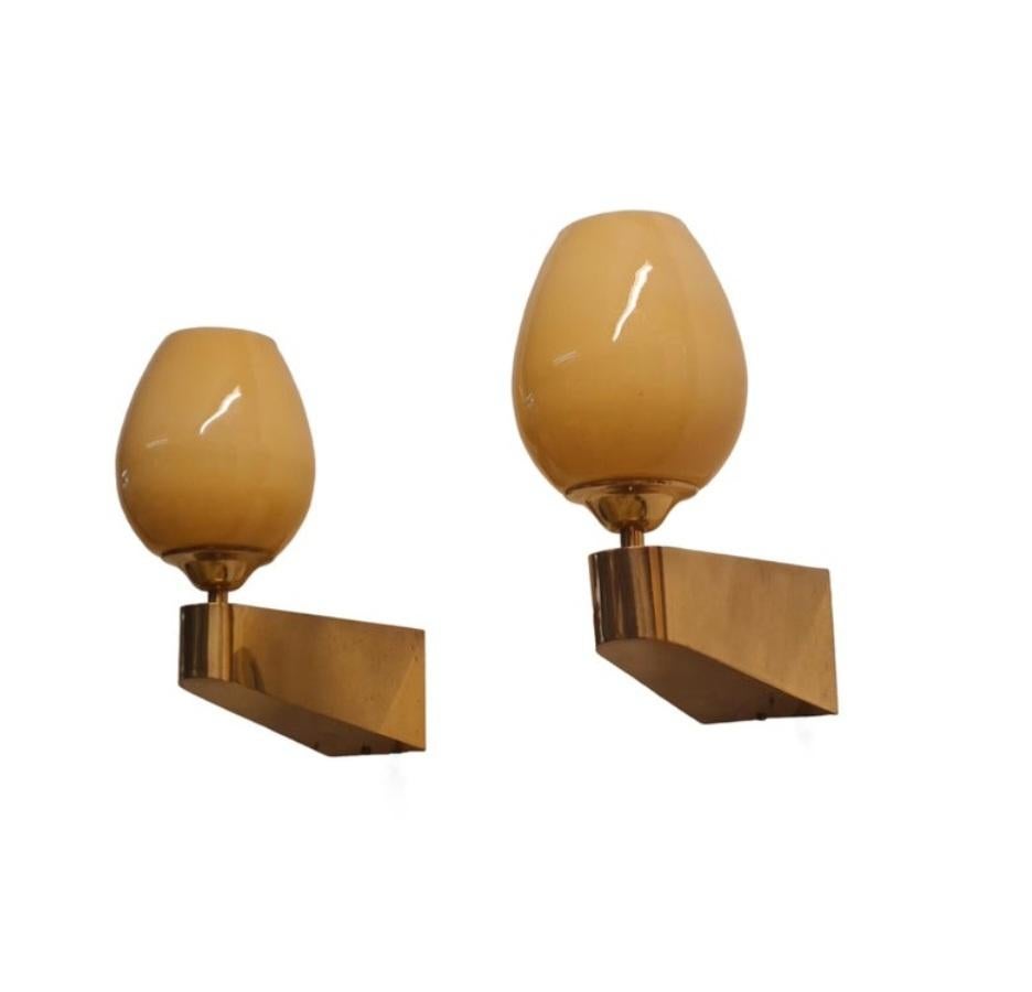 Una bella coppia di lampade da parete in ottone pieno, realizzate da Itsu in Finlandia negli anni Cinquanta. Model EY 49. 

Le lampade sono minimaliste, con un design cubico ammorbidito dalle curve e coronato da un paralume in vetro soffiato a mano.