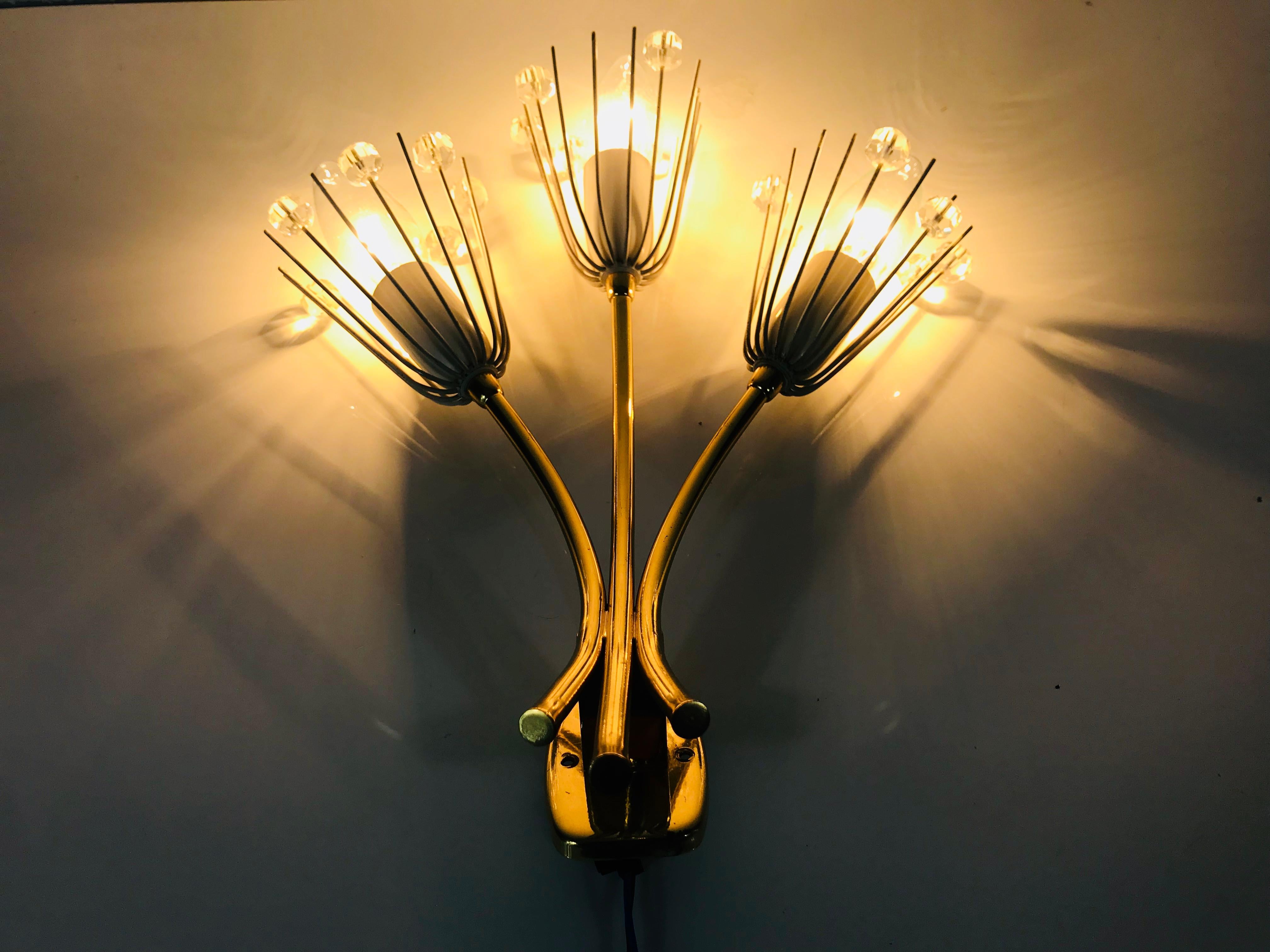 A beautiful pair of brass wall lamps made by Emil Stejnar for Rupert Nikoll, Austria in the 1960s. The pair has an amazing midcentury design. It is made of brass and small glasses and fits perfectly into a living room. The fixture has a very nice