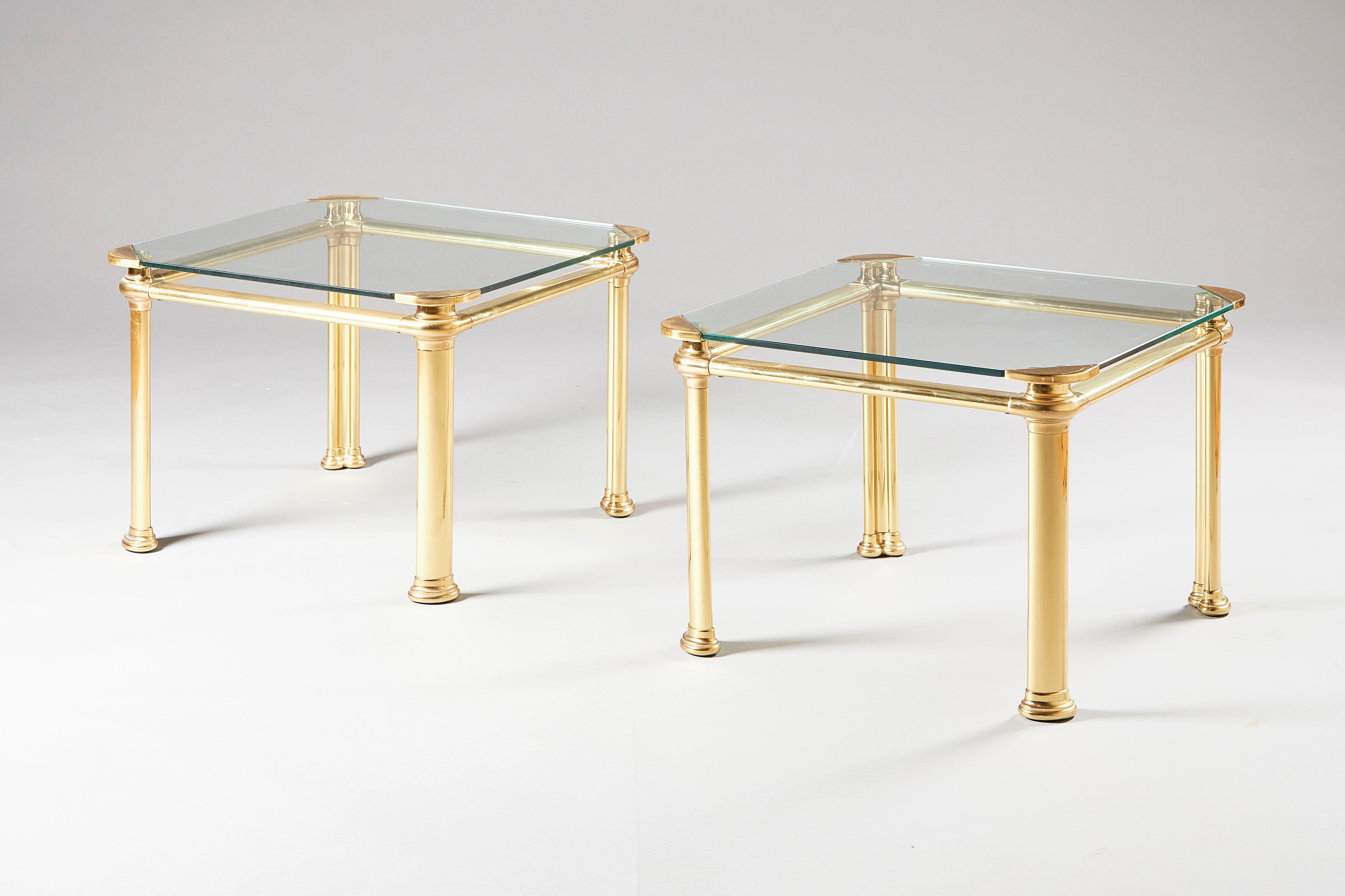 A pair of lacquered brass side tables, likely Italian, 1960s, of square form, on column shaped legs, with removable glass inset tops.
