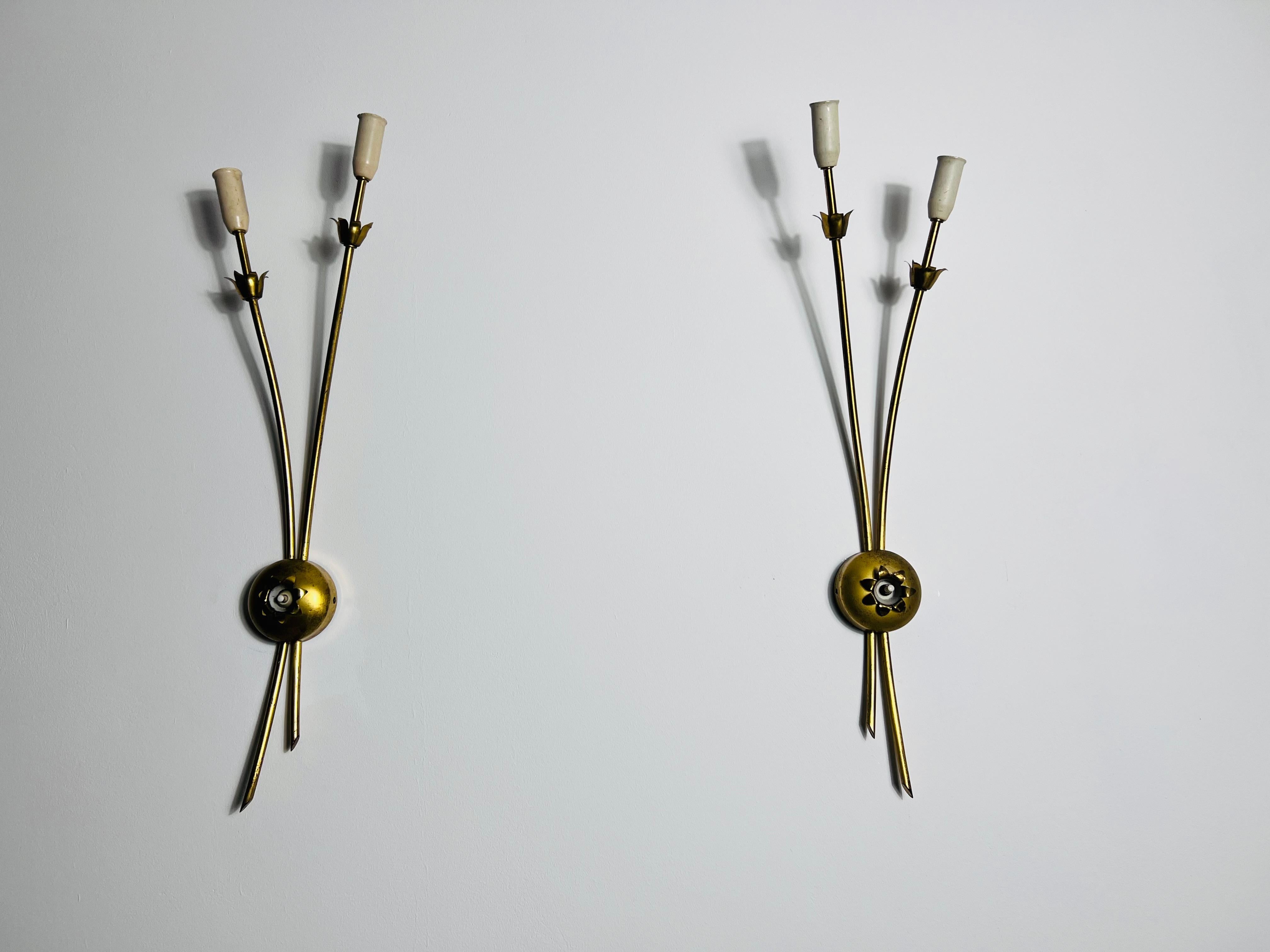This rare and elegant pair of Sputnik wall lamps from Italy, dating back to the 1960s, exemplifies mid-century sophistication. Each lamp features a slender brass rod and body, giving it an elongated and extravagant silhouette that makes a bold