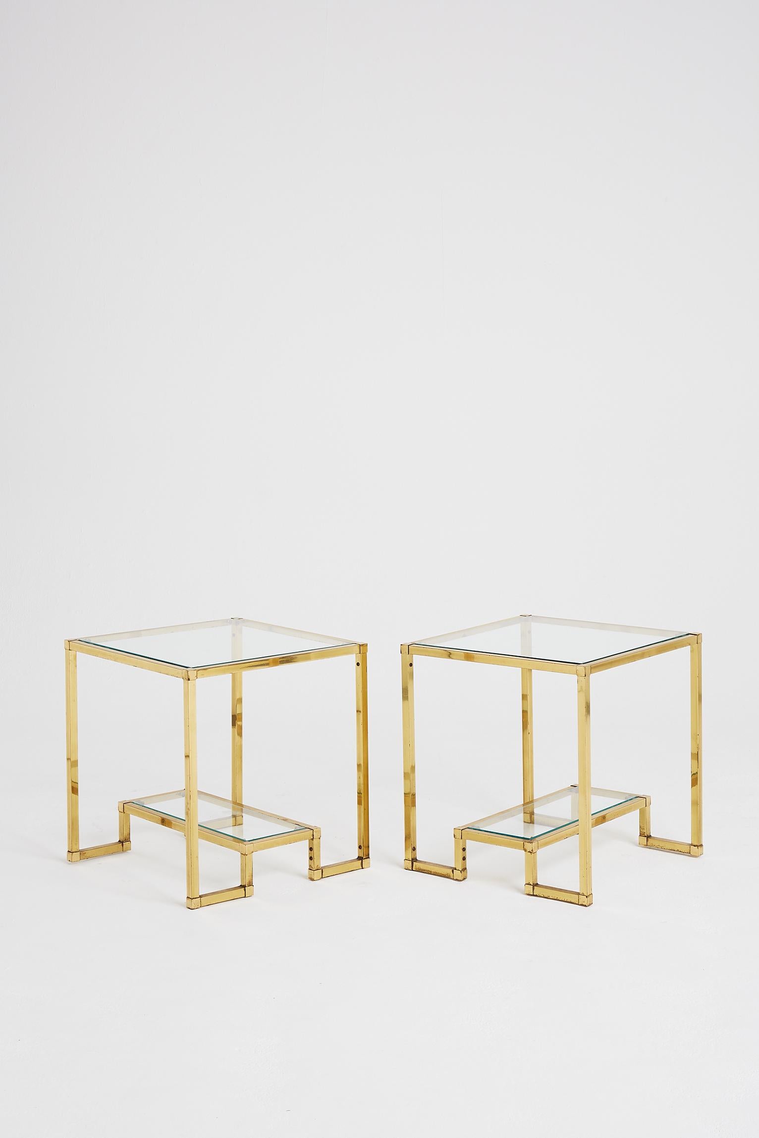 A pair of brass and glass two-tiered side tables.
France, circa 1970.