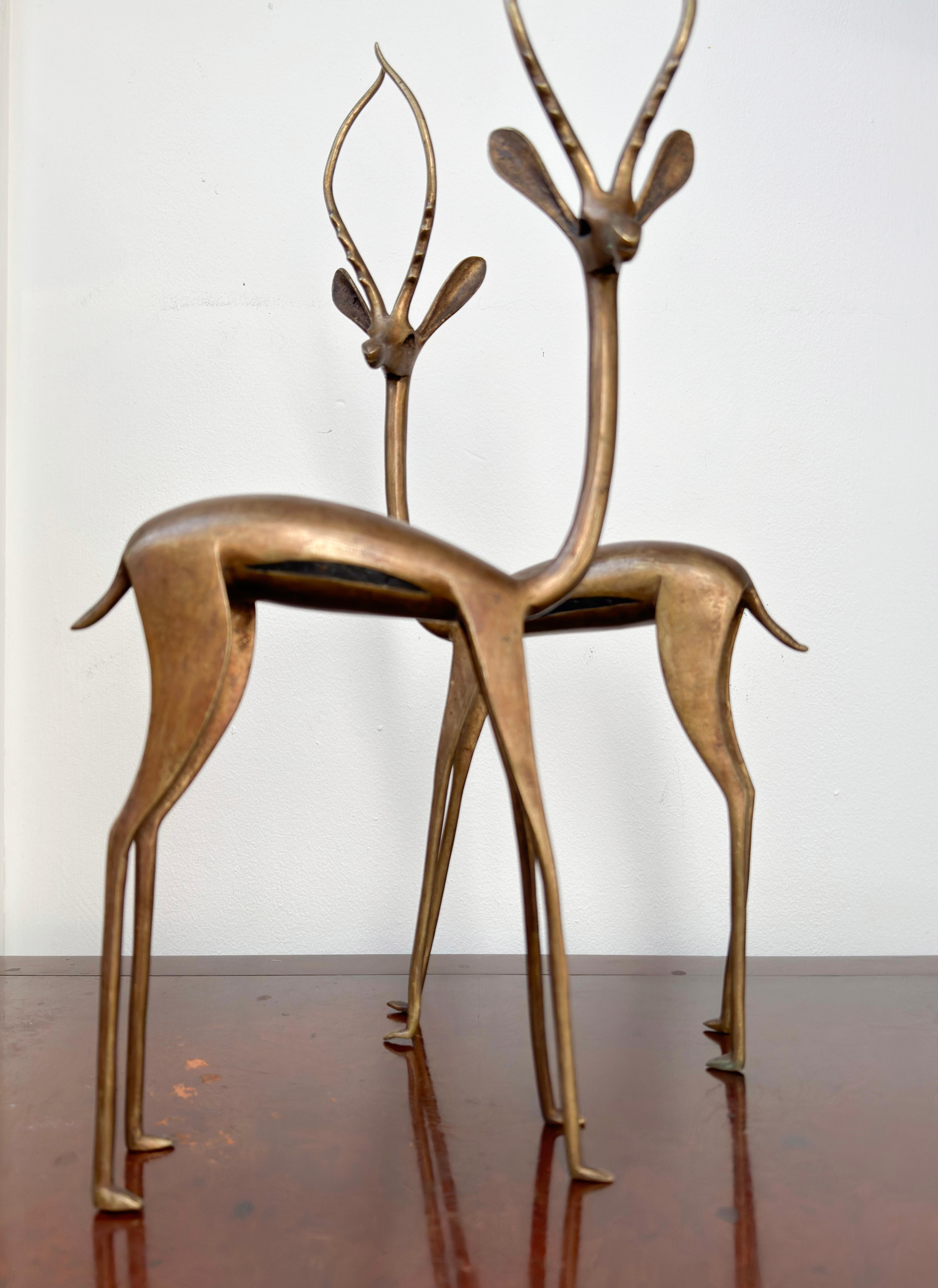 A pair of mid-century bronze gazelle sculptures. The ornamental sculptures were handcrafted in the 1960s by the renowned Tuareg Tribe in Africa. The sculptures offer a stylized interpretation of gazelles, characterized by their long, slender forms