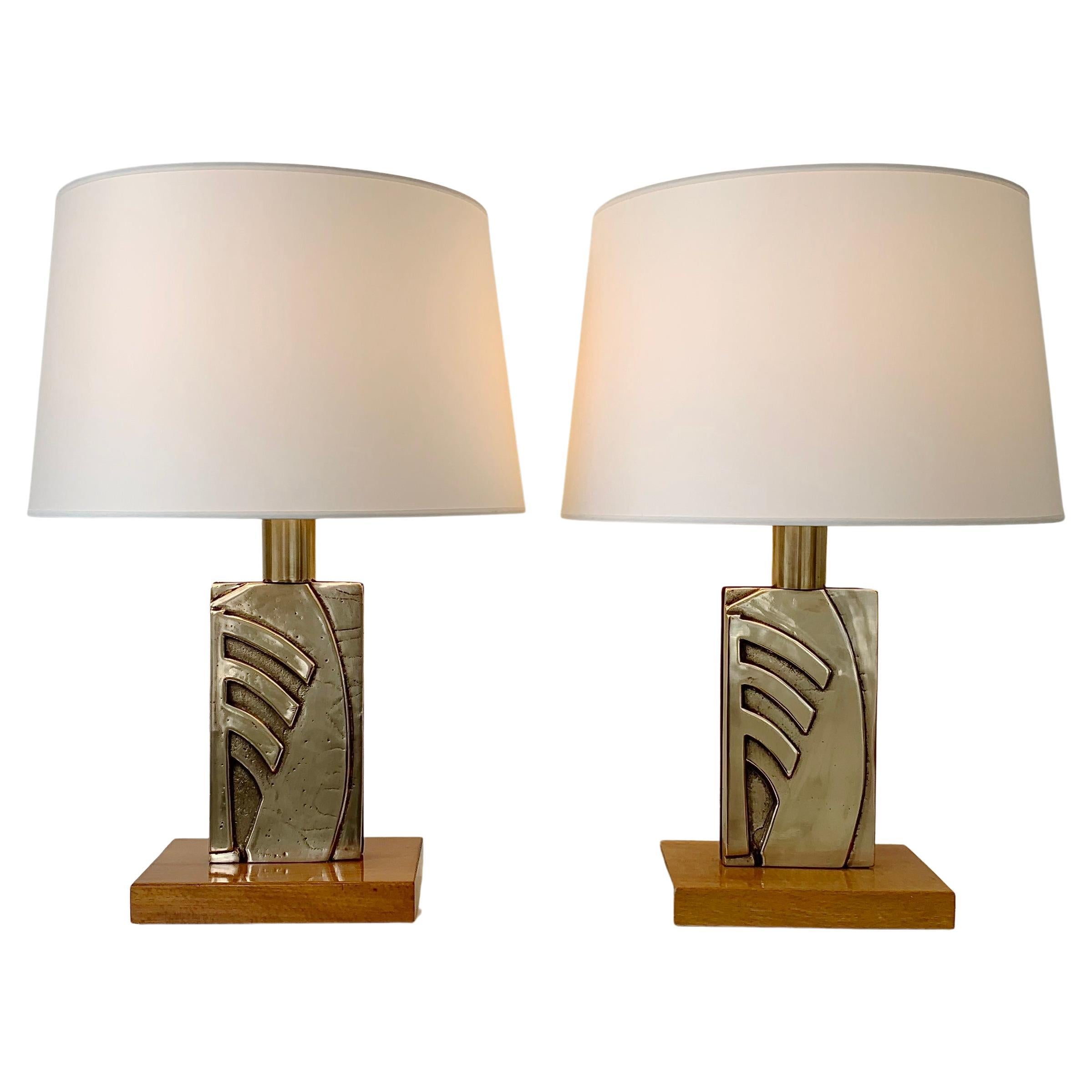 Elegant pair of midcentury table lamps, circa 1970, Italy.
Polished bronze, solid oak base, brass, new white fabric shades.
Rewired. 
Dimensions: 58 cm total height, 40 cm W, 40 cm D. 
Wood base: 22 x 15 cm, decorative bronze: 23 x 13cm
All