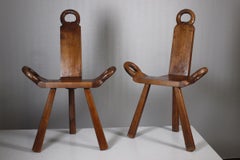 Pair of mid century brutalist tripod chairs with hand carved details