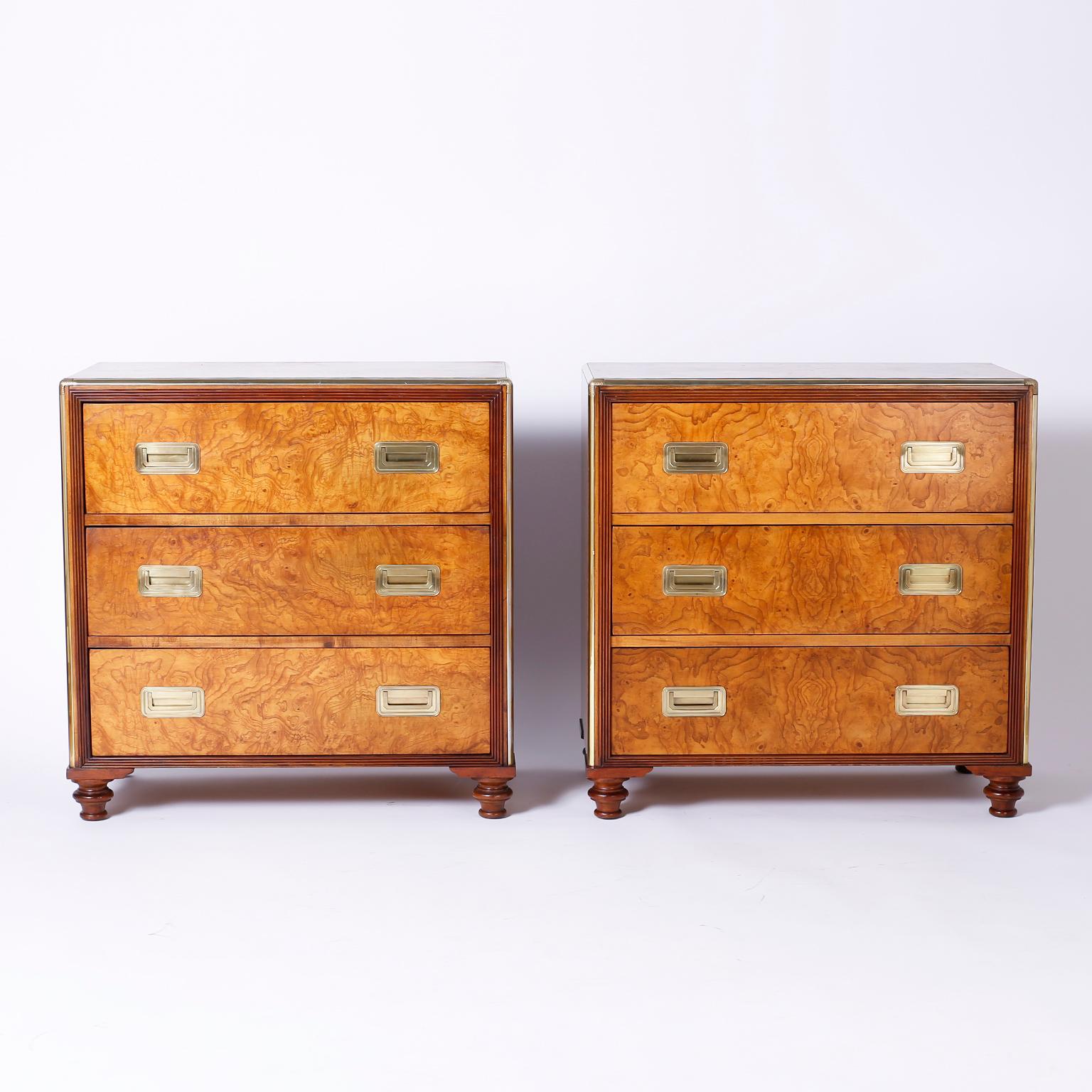 Refined pair of Campaign style three-drawer chests crafted in exotic burled walnut with brass hardware and turned feet. Perfect combination of traditional and modern. Signed Baker in a drawer.