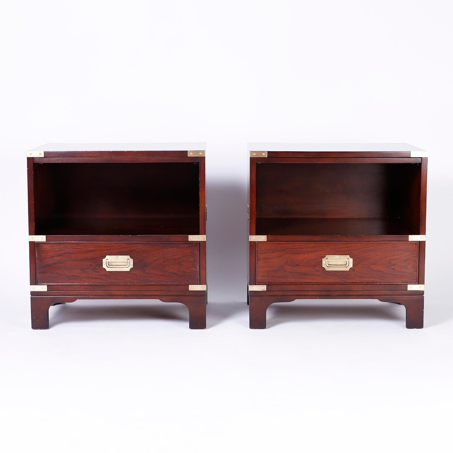 Pair of mahogany nightstands with Campaign style brass hardware, slide out tray, storage space over a drawer and Classic bracket feet. Signed Beacon Hill Collection in a drawer.