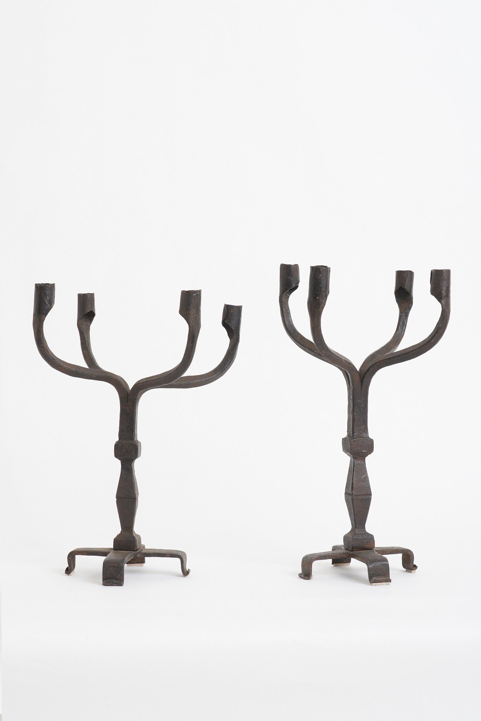 A pair of forged iron four-armed candelabras.
France, 1950s.