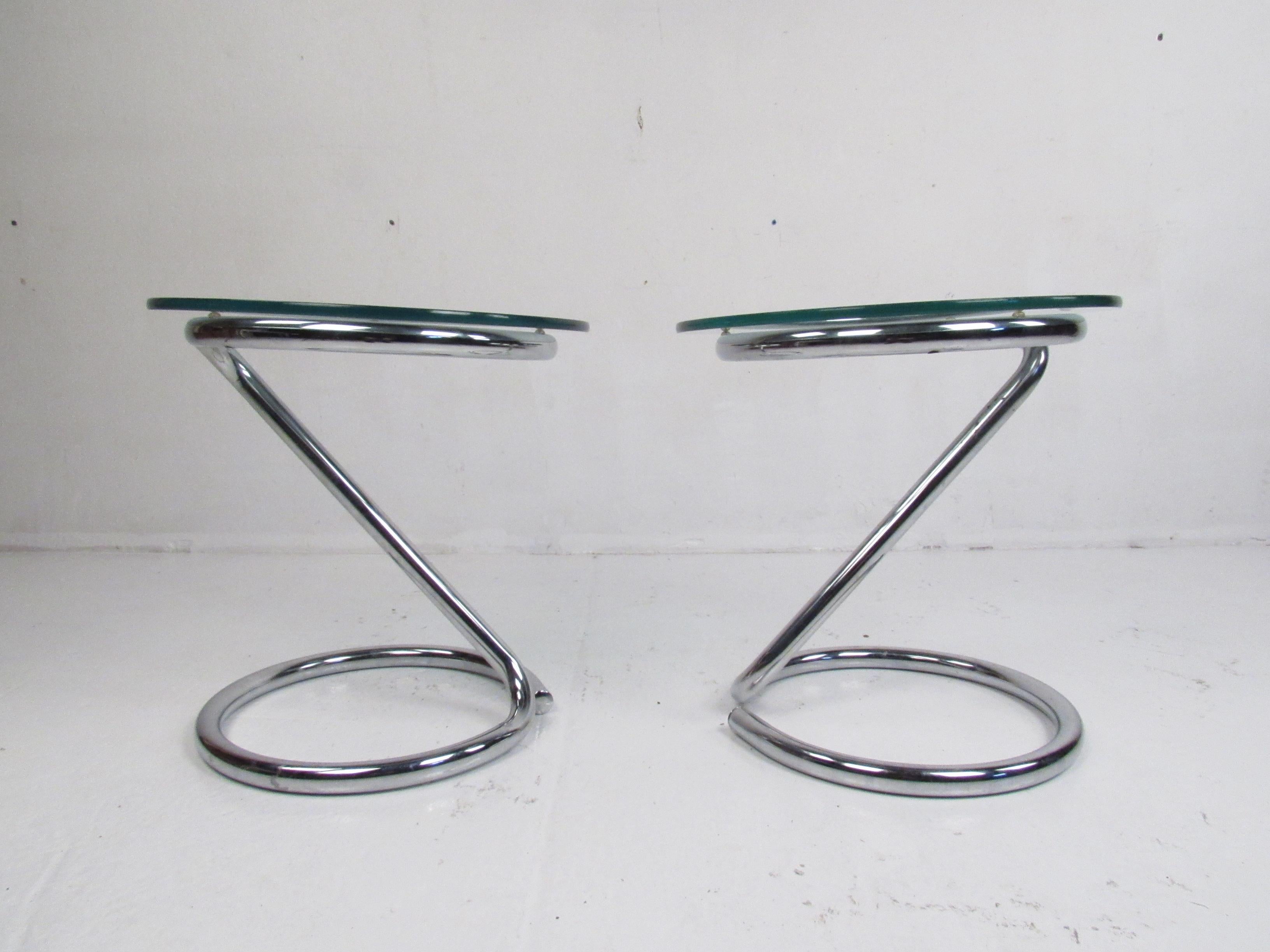 Cette étonnante paire de tables d'appoint vintage modernes est dotée d'un cadre tubulaire chromé en porte-à-faux et d'un plateau circulaire en verre. Un design inhabituel et élégant qui ne manquera pas de faire une impression durable dans tout
