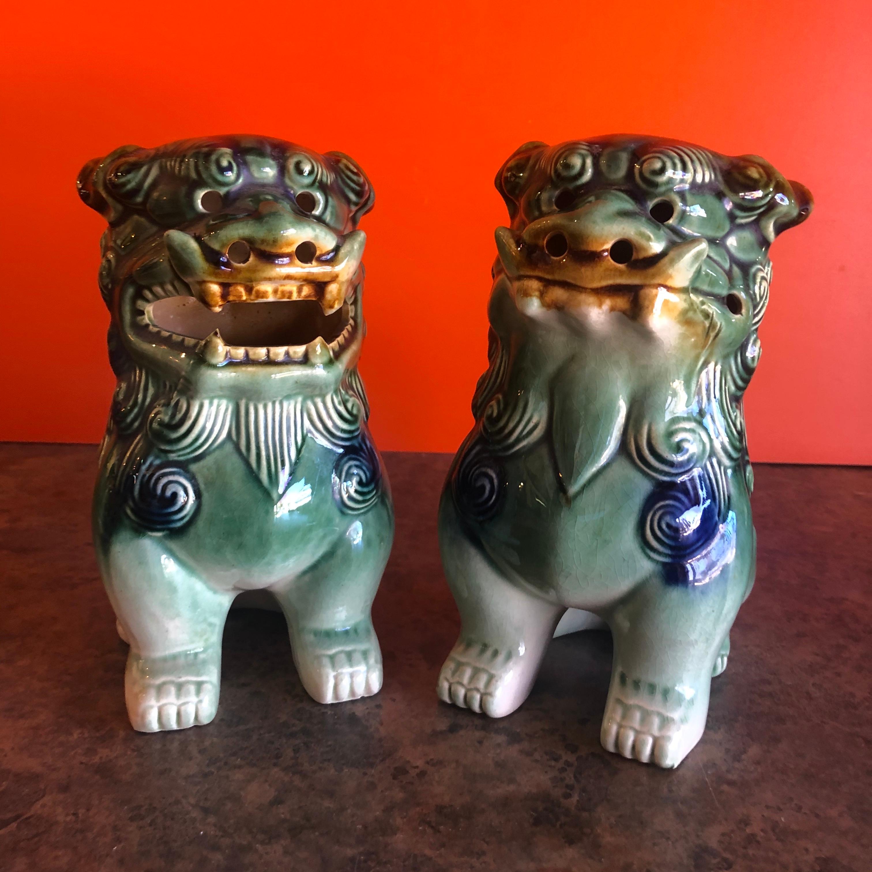 A very nice pair of vintage green, white and blue ceramic foo dogs, circa 1970s. Excellent condition and patina; makes a great pair of book ends or a fun decor item in any room! #1080.