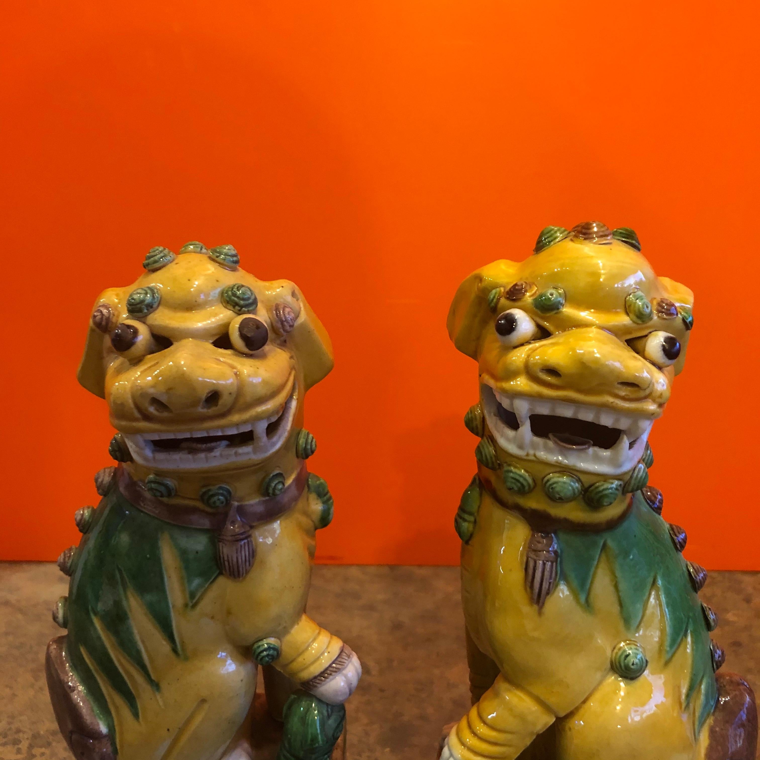 Great pair of midcentury ceramic foo dogs or bookends made in China, circa 1960s. Great detail and a beautiful color combination of yellow, green and brown; the dogs are not a perfect match and may be a married pair, but they go together great and