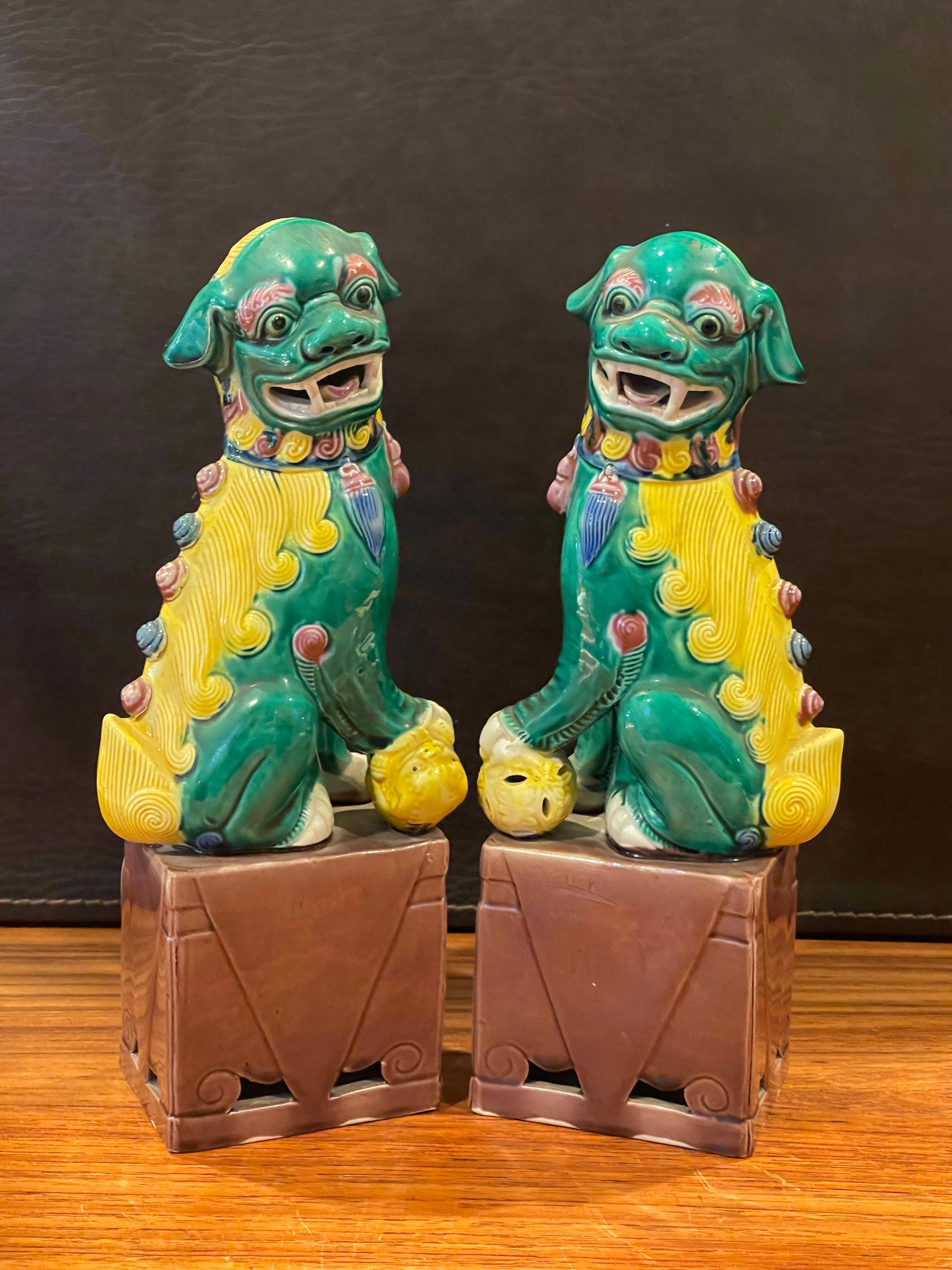 Great pair of midcentury ceramic foo dogs or bookends made in China, circa 1960s. Great detail and a beautiful color combination of yellow, green and brown; the pair measure 8