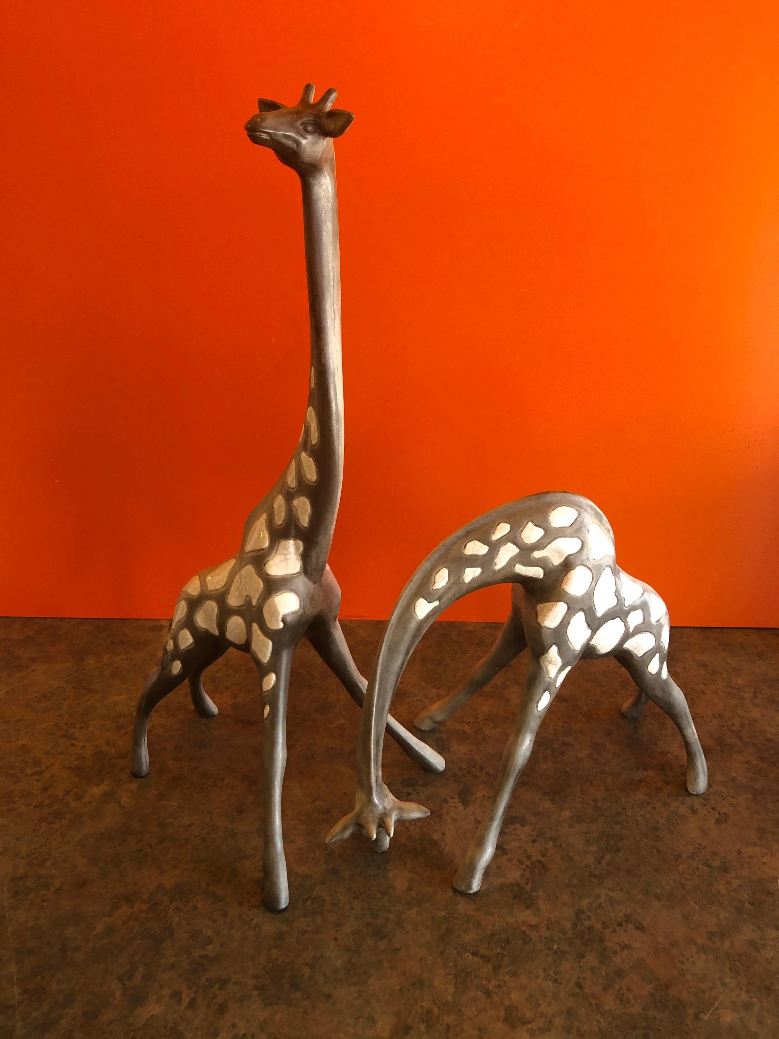 Merveilleuse et difficile à trouver paire de girafes en céramique du milieu du siècle par McFarlin Freeman Pottery, circa 1960s. La paire est bien détaillée et super délicate, la grande girafe mesure 8,25