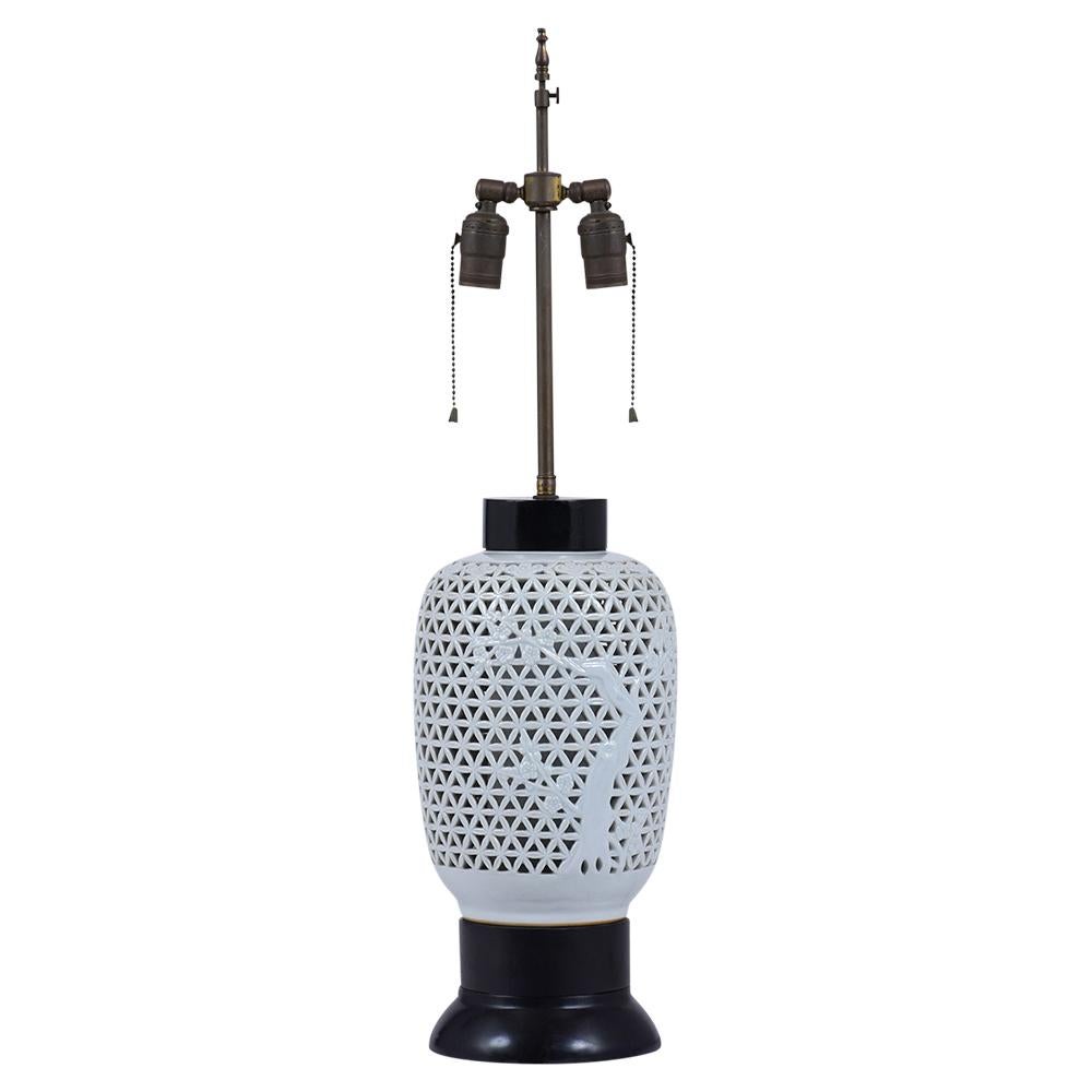 An extraordinary pair of mid-century porcelain table lamps feature an oriental design beautiful glazed finish the vase rests on a round wooden base painted in black color. The harp has adjustable lights, is wired to US standards, and is in working