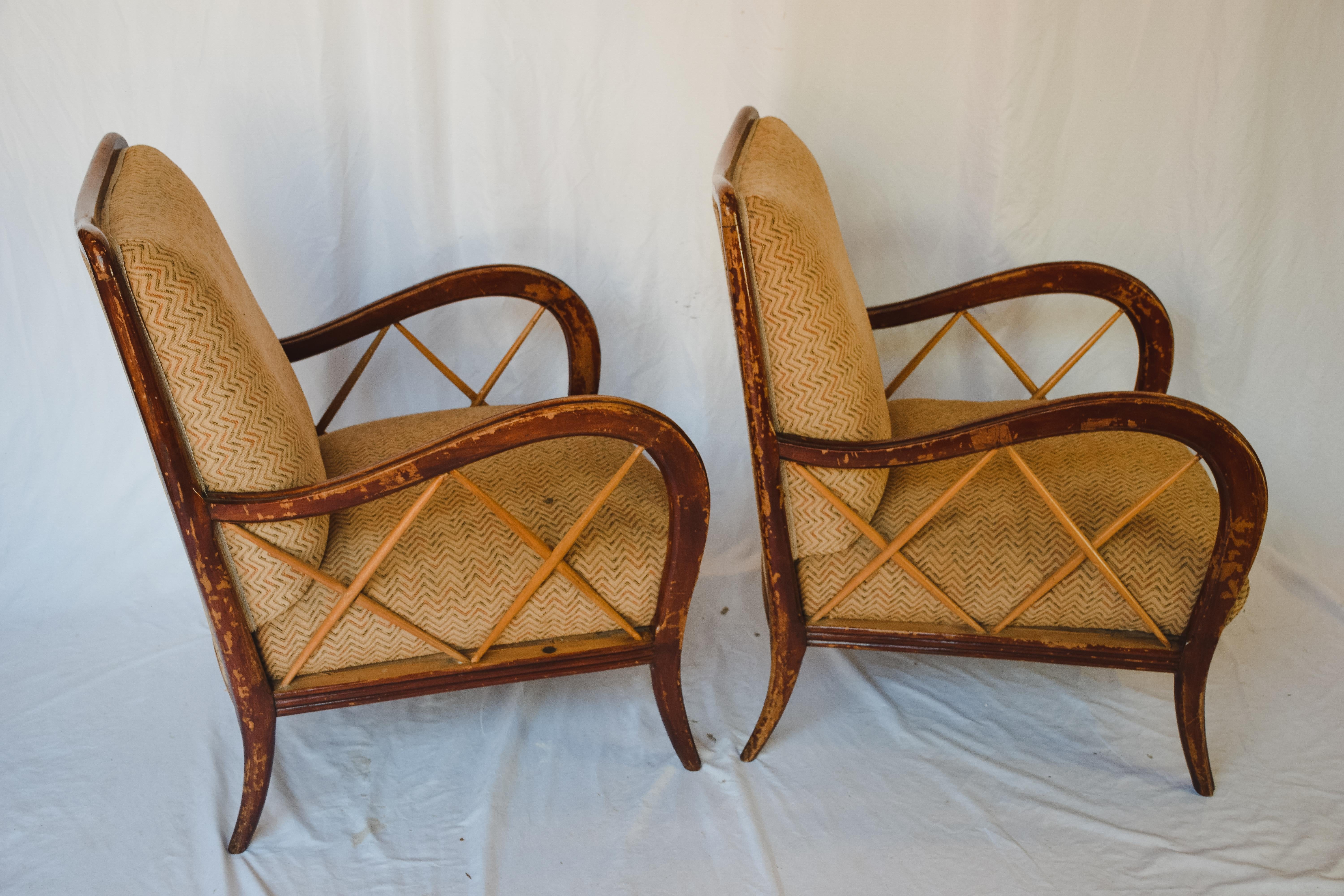 An unusually beautiful pair of vintage lounge chairs from Italy. Made of solid wood with an upholstered seat and back. A beautiful worn patina with a nod to a bamboo style detail on the sides of the arms. The current fabric does not appear to be