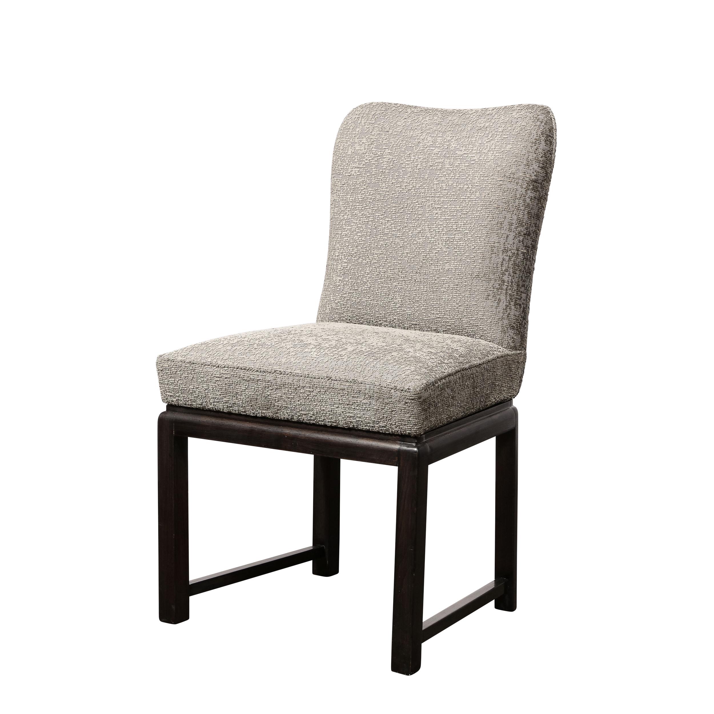 Dieses elegante Paar von Mid Century  Stühle wurden in den Vereinigten Staaten um 1950 realisiert. Sie haben zylindrische Beine mit geradlinigen Querstreben aus ebonisiertem Nussbaum. Die Oberseite der Rückseiten ist mit einem subtilen,