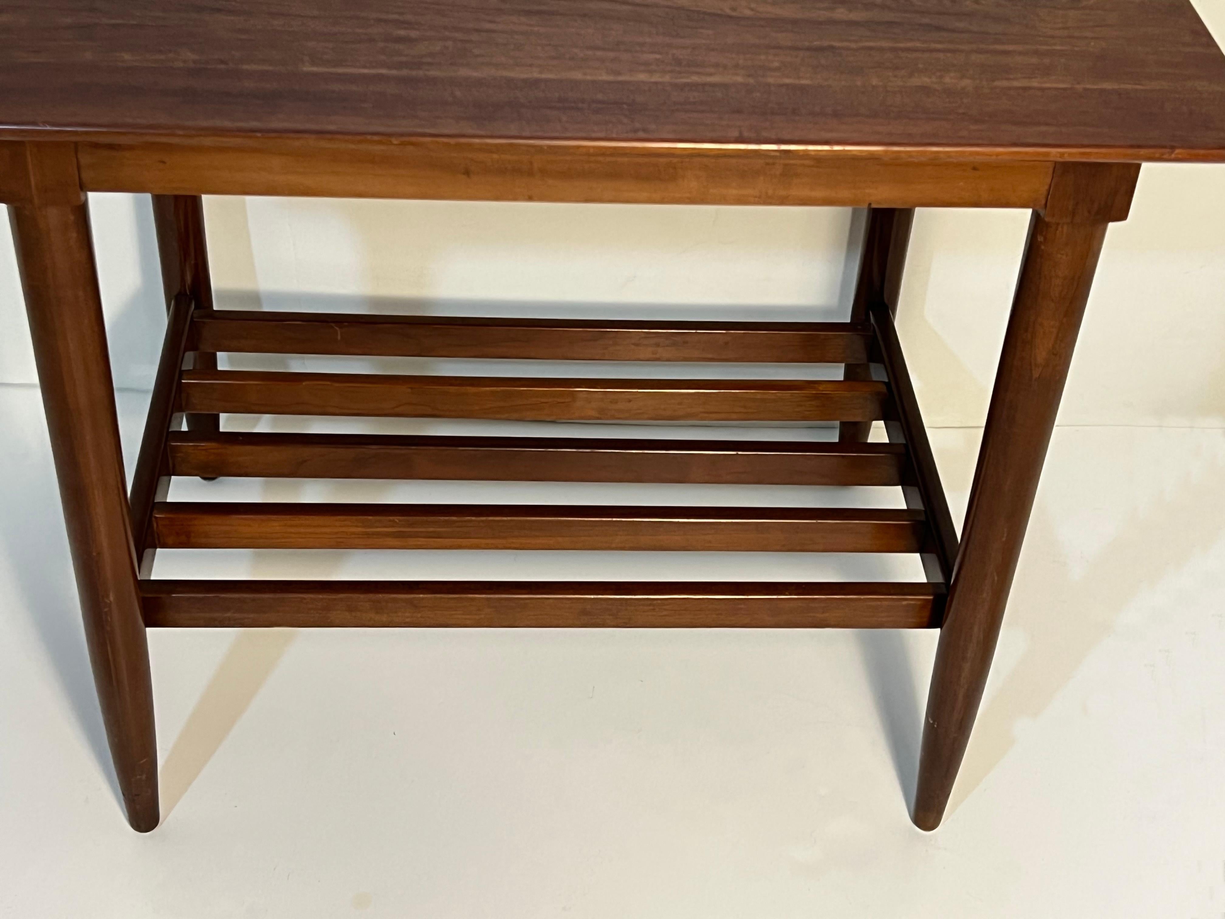 These side tables are made of solid cherry. The slatted bottom tier is very convenient for storing books or magazines as it prevents them to get moldy.
The Willett Furniture company was founded in 1934 by W.R. Willett and C.H. Willett. 
The