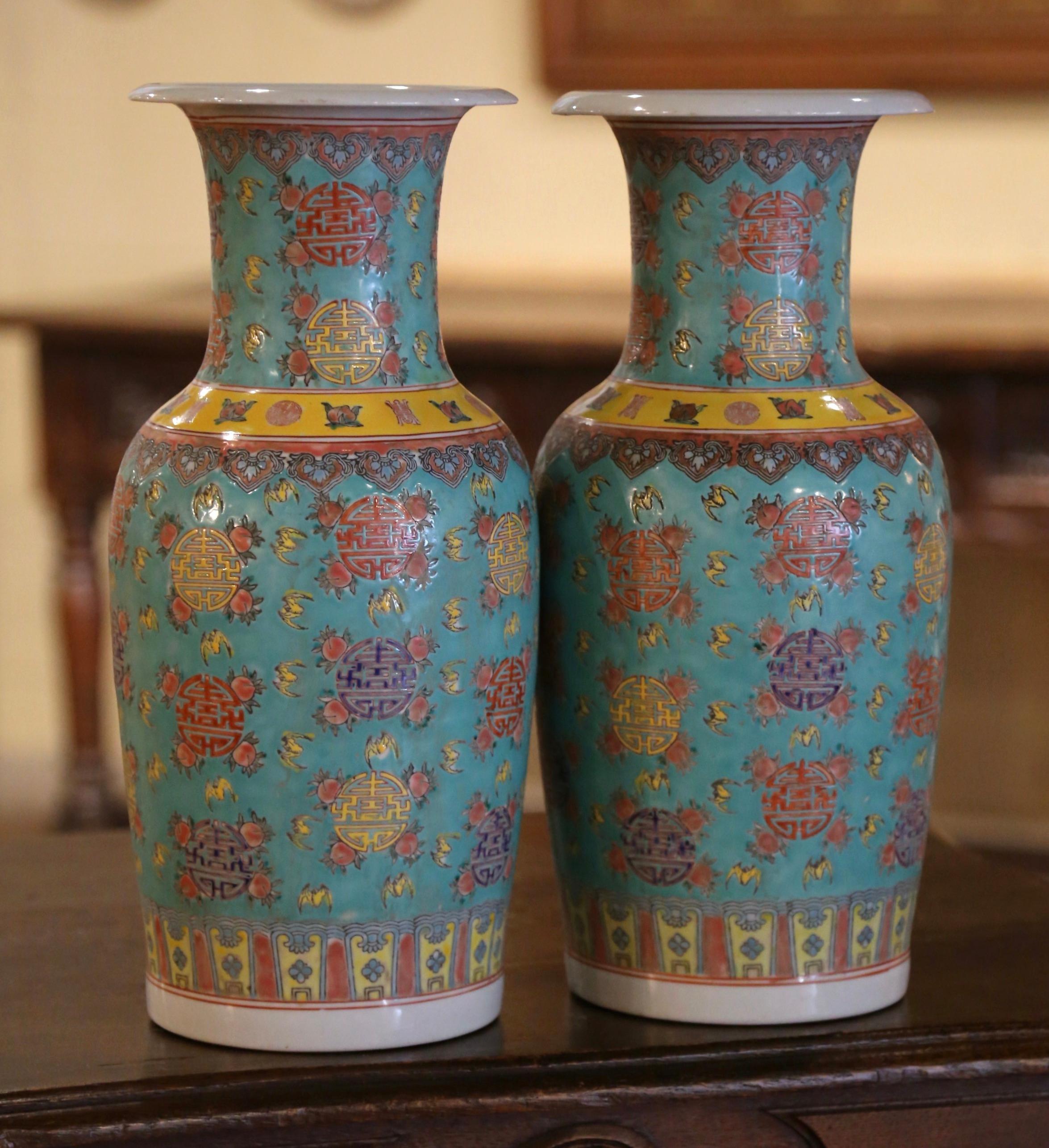 Diese eleganten, farbenfrohen Famille-Rose-Vasen wurden um 1950 in China hergestellt. Die großen, hoch aufragenden Gefäße haben einen ausgestellten Rand und einen runden Körper. Jeder Körper ist mit Fledermaus- und Pfirsichmotiven verziert, die für