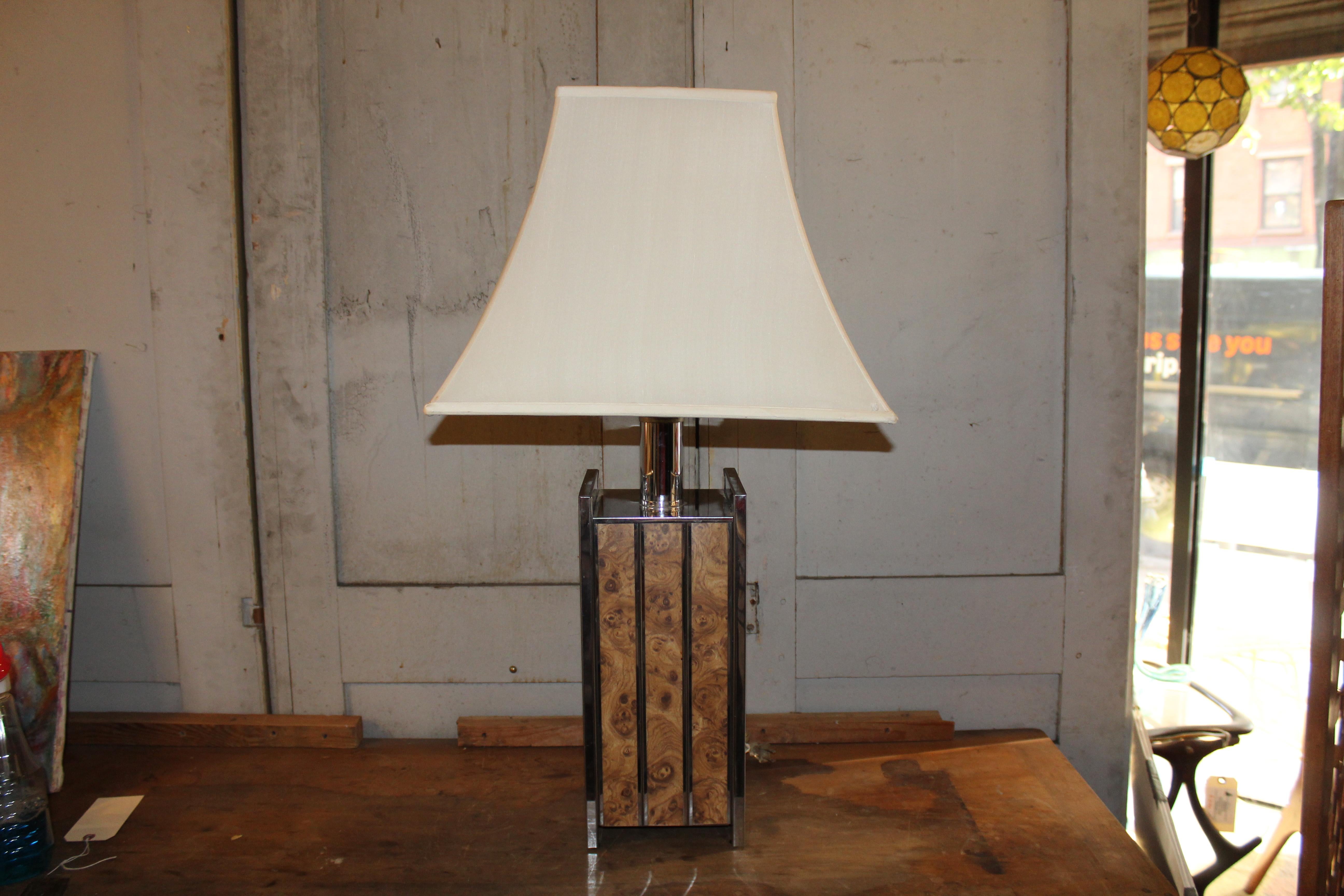 Striking pair of tall mid-century table lamps featuring chrome bodies accented with burled panels. Their bold design and sculptural height make them standout statement pieces, perfect for adding character and warmth to any interior.

Please confirm