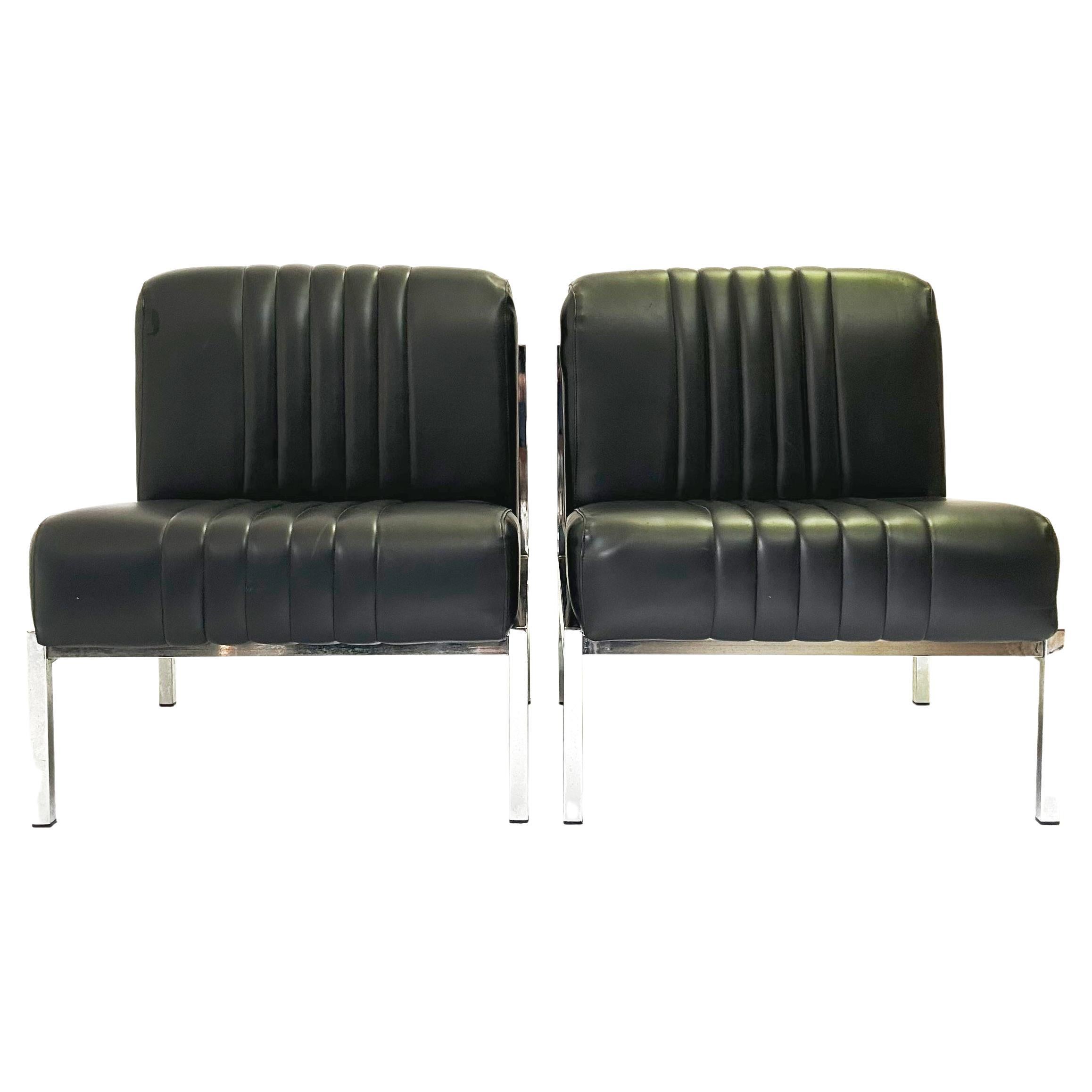 Schönes Paar Vintage schwarz Kunstleder niedrigen Stühlen aus den 1970er Jahren. In Anlehnung an die niedrigen Sitze, die in den 1970er Jahren für den Pariser Flughafen Orly hergestellt wurden.