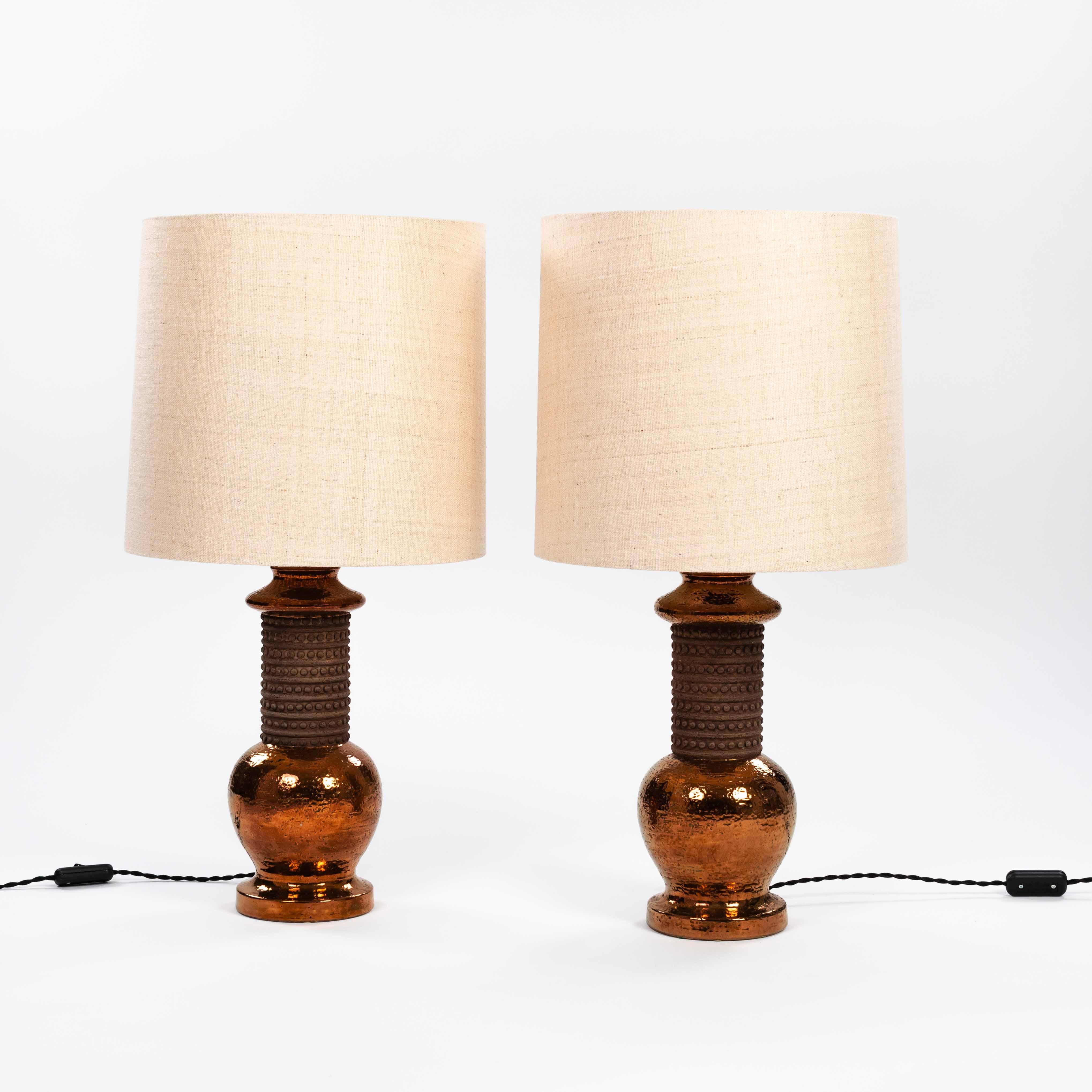 Elegant, rustic pair of table lamps in ceramic with copper glaze by Bergboms AB Sweden for Bitossi Italy 1960s. 
Beautifully shaped design with matte open pore ceramic center and copper colored glaze of round lamp base and lamp neck. 
Brown earthen