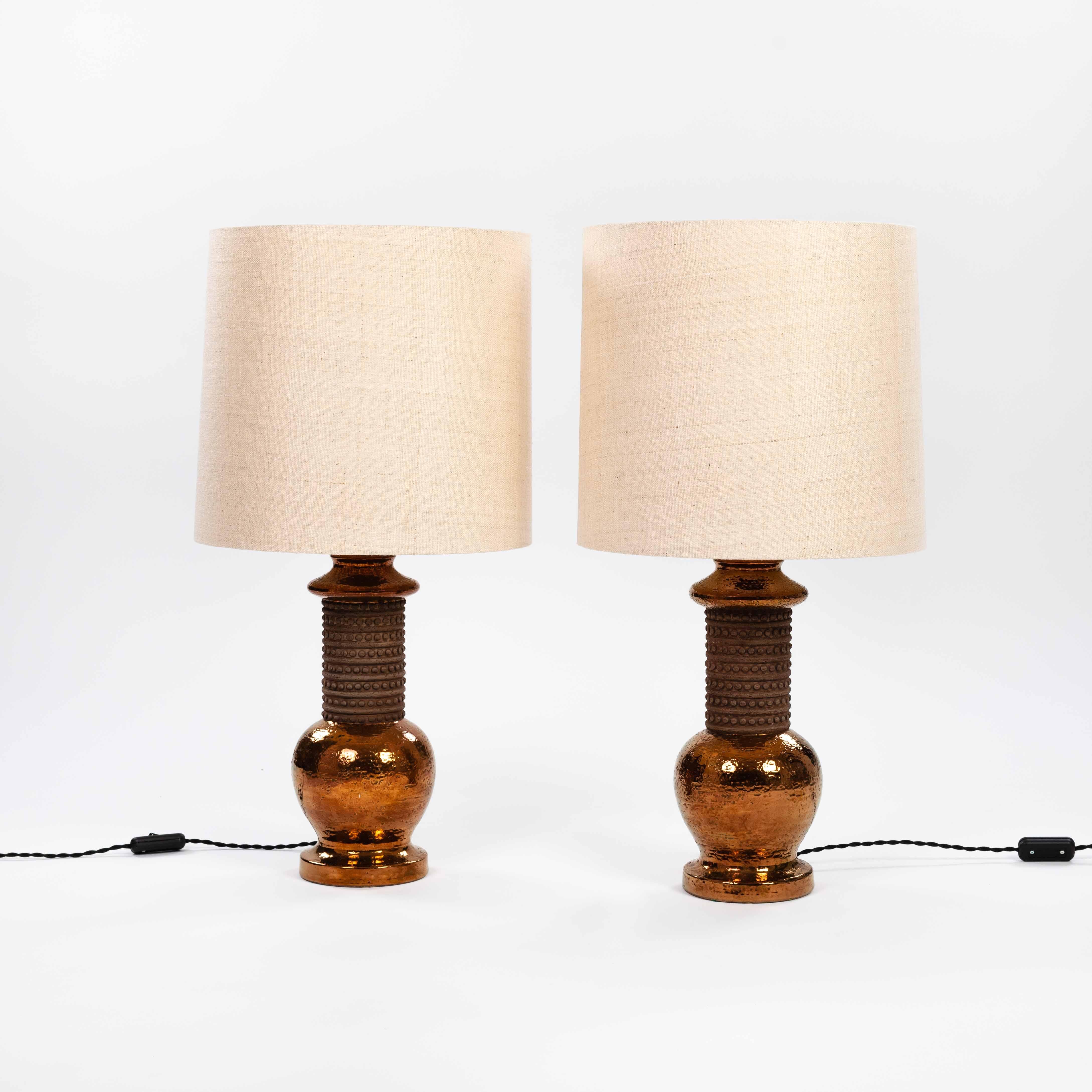 Elegante y rústica pareja de lámparas de sobremesa en cerámica con esmalte cobrizo de Bergboms AB Suecia para Bitossi Italia años 60. 
Diseño de bella forma con centro de cerámica de poro abierto mate y esmalte de color cobre de la base redonda y el