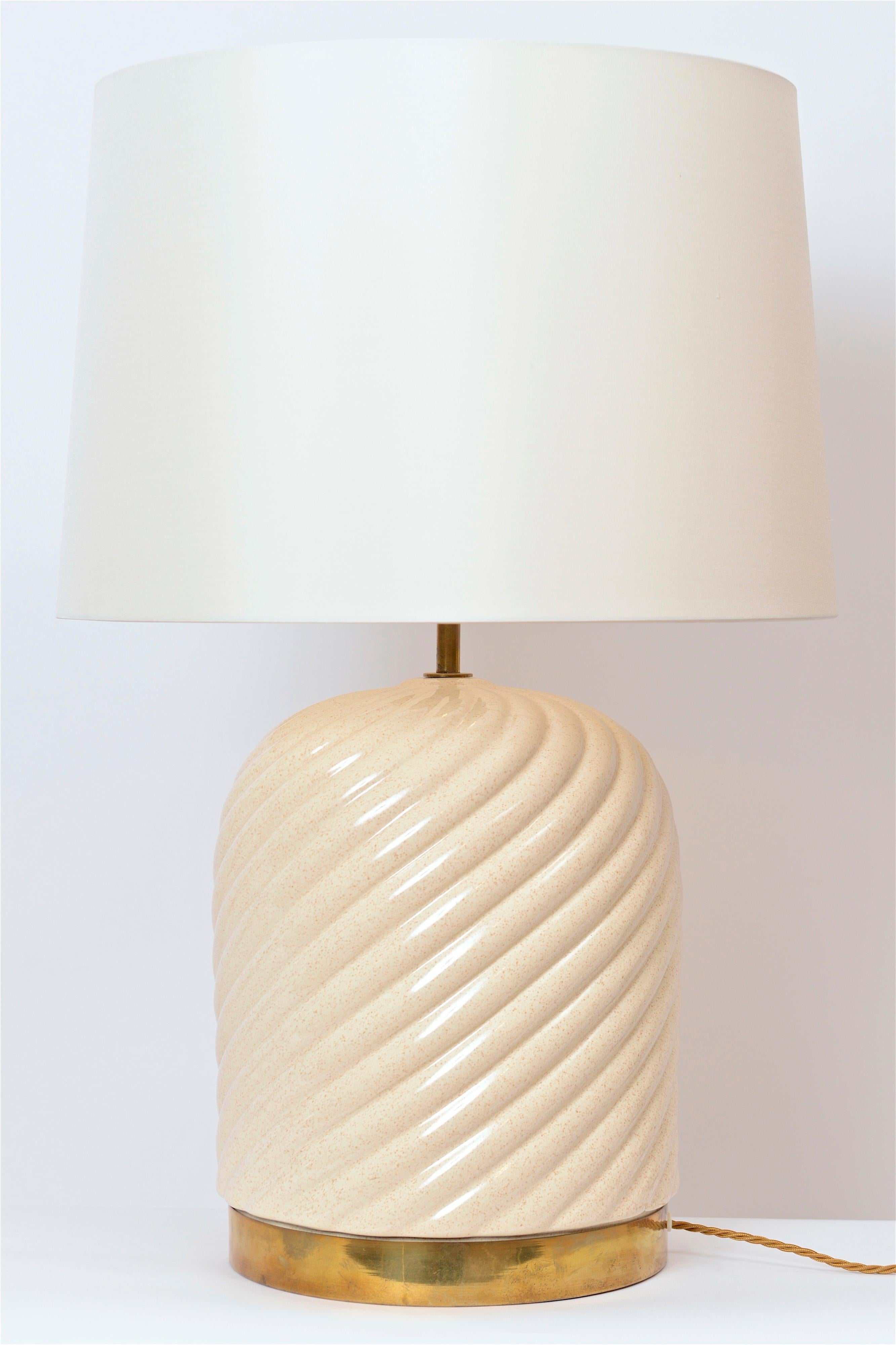 A wonderful pair of cream glazed ceramic table lamps designed by Tommaso Barbi. Manufactured for Barbi by B. Ceramiche in the 1970s, the lamps spiralling ceramic body is finished at the base with Barbi’s signature brass band. Newly re-wired, the