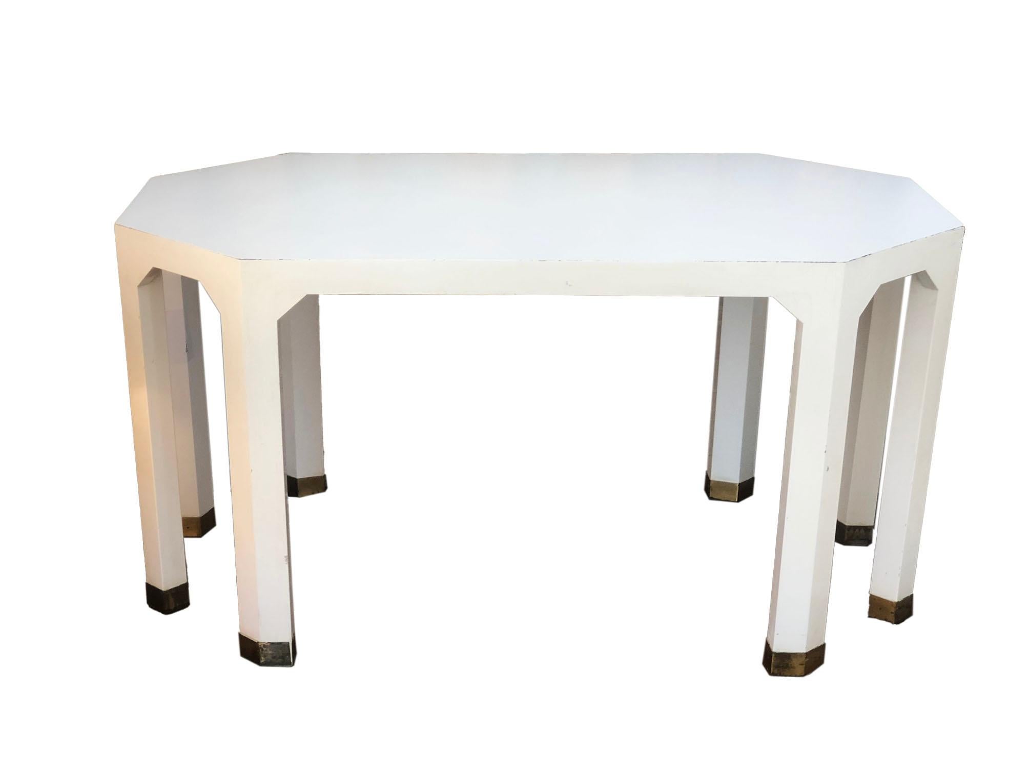 This pair of unique rectangle octagon corners end tables from midcentury have a crackle paint finish on the legs. The legs also have brass feet. The top of the table is cream laminate and blends into the paint almost seamlessly. These tables make
