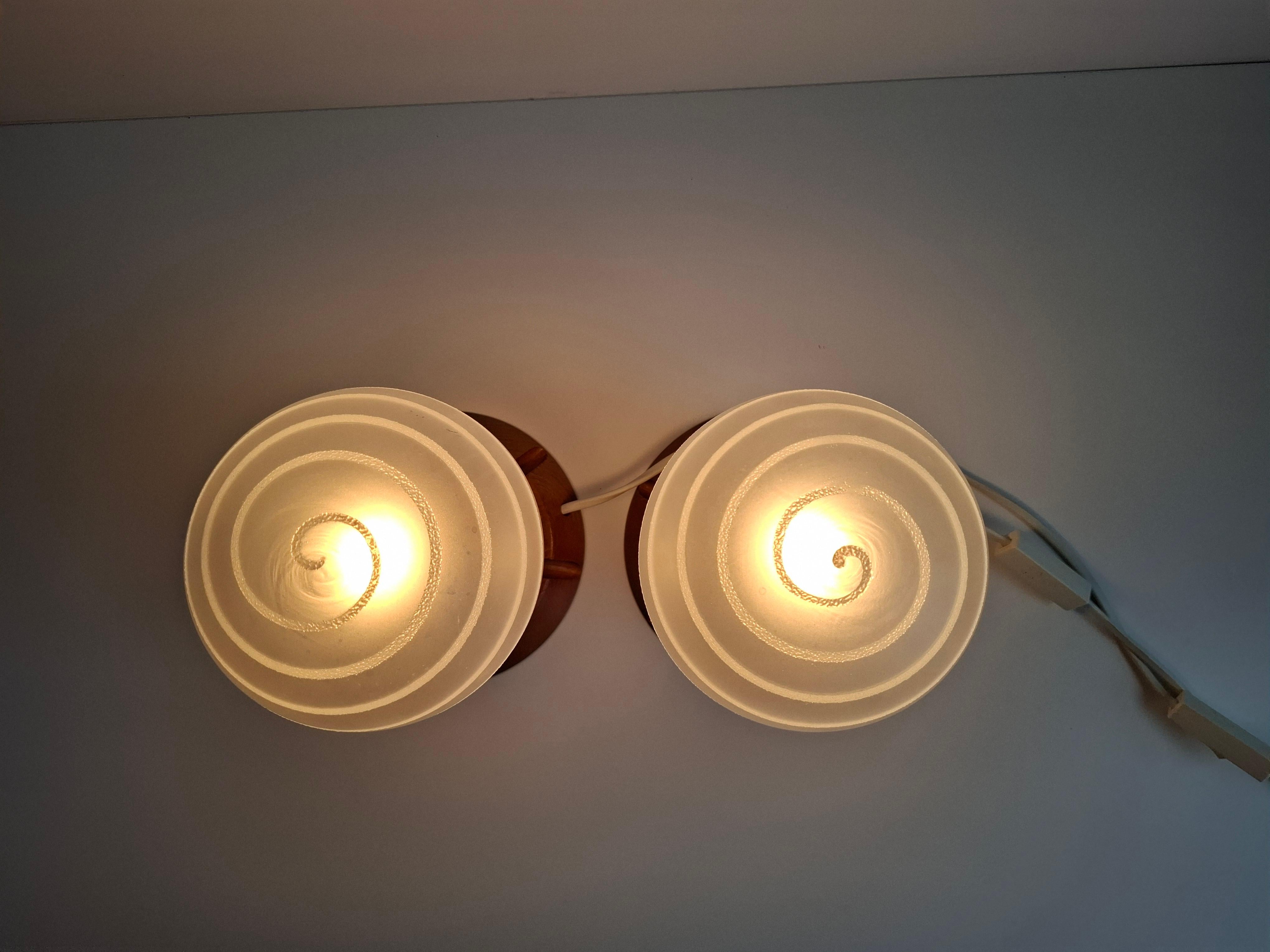 Cette paire de lampes de table du milieu du siècle provenant de la République tchèque (1990) combine des bases en bois sculpté, des globes en verre dépoli avec des détails rayés et des accents chromés. Les deux lampes sont en bon état vintage avec