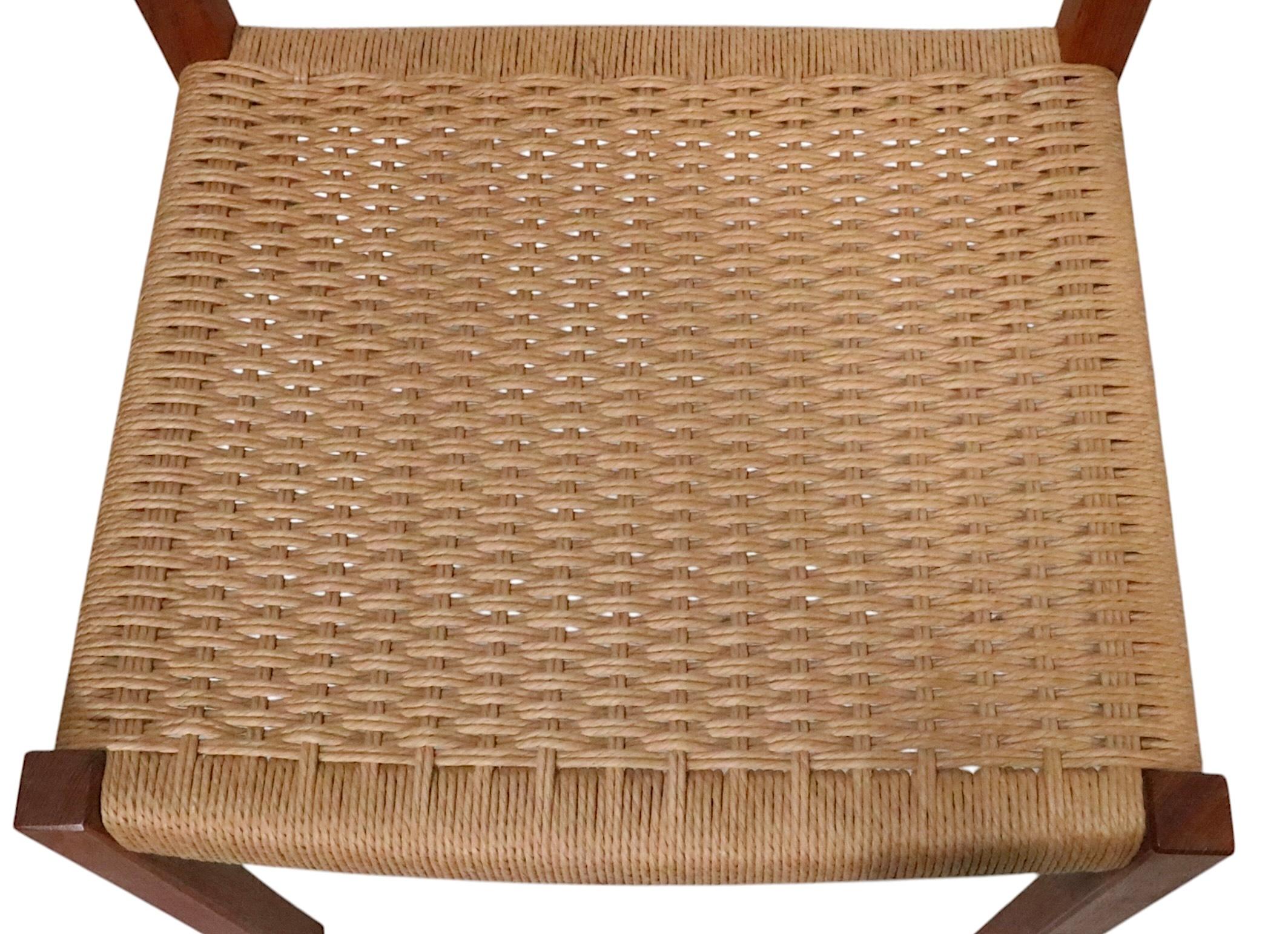 Pareja de sillas de comedor sin brazos de la modernidad danesa de mediados de siglo, diseñadas por Jorgen Henrik Moller para J. L.  Moller Mobelfabrik, modelo 404, hacia la década de 1970 .
 Las sillas son de teca maciza, con asientos de cuerda de