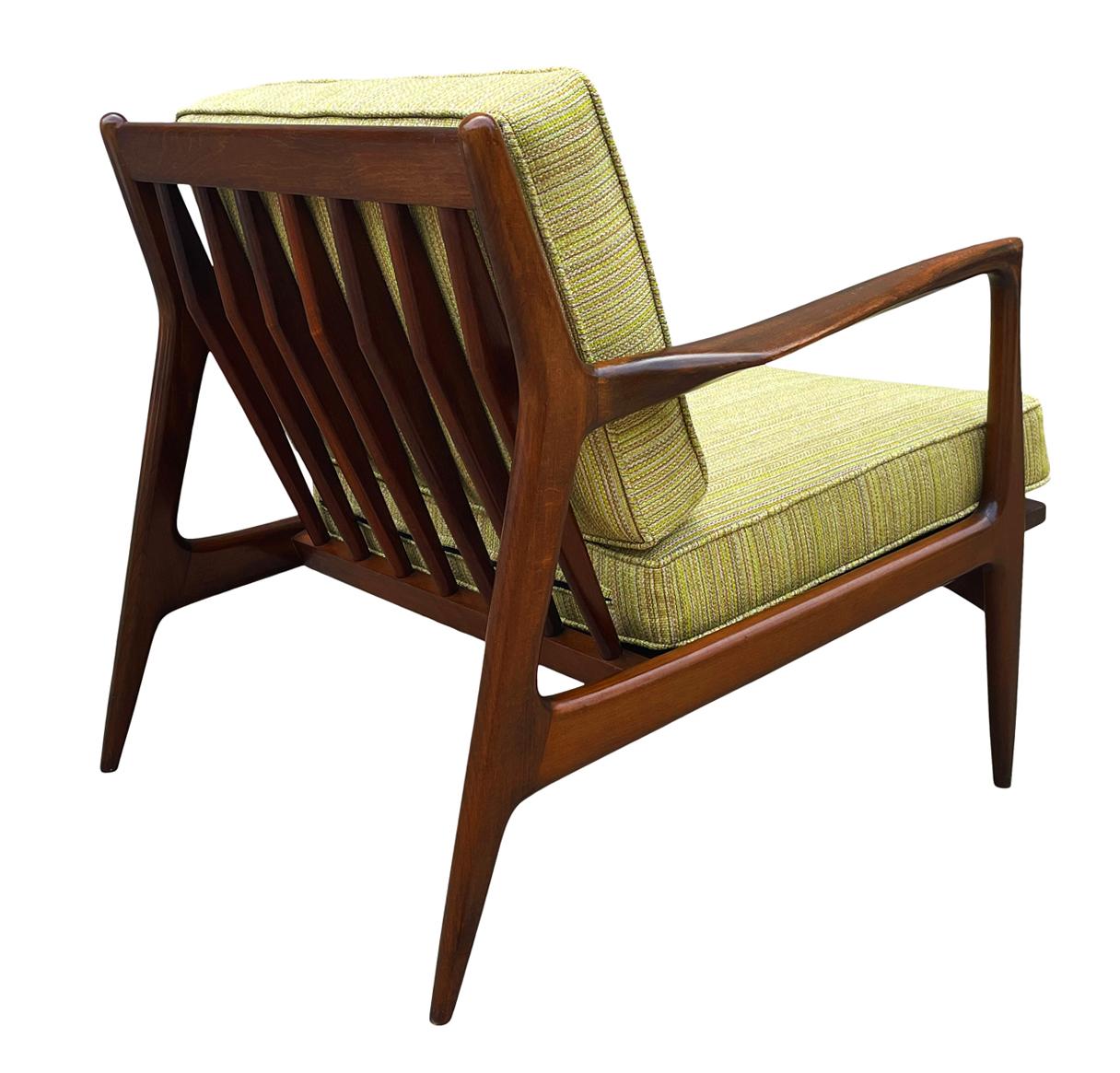 A stunning pair of vintage IB Kofod-Larsen lounge chairs produced by Selig in Denmark ca. 1950's. They feature solid walnut frames with restored upholstery and seat webbing. Price includes the pair.