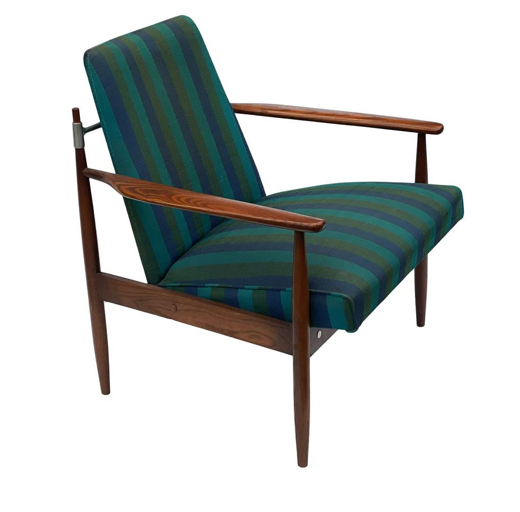 A stylish pair of American modern walnut lounge chairs in the style of Finn Juhl. The feature solid walnut construction, aluminum details and the upholstery is original. Reupholstery is recommended but perfectly usable as is.
