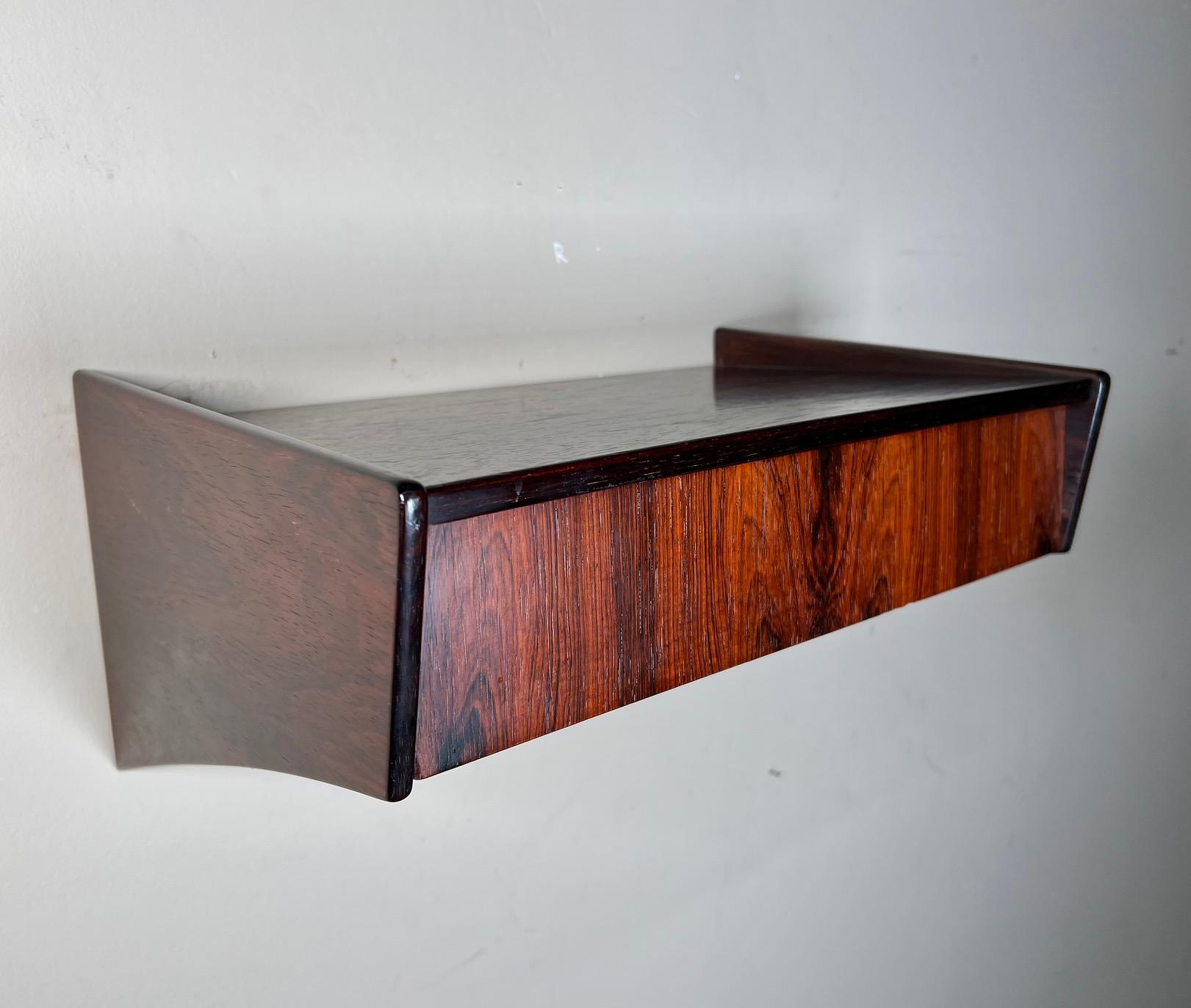 This is a set of Danish rosewood floating shelves. They could be used as nightstands or floating side tables. Featuring a drawer each. Mounted with 2 screws each (screws not included). Original makers stamp on the back.

They are in very good