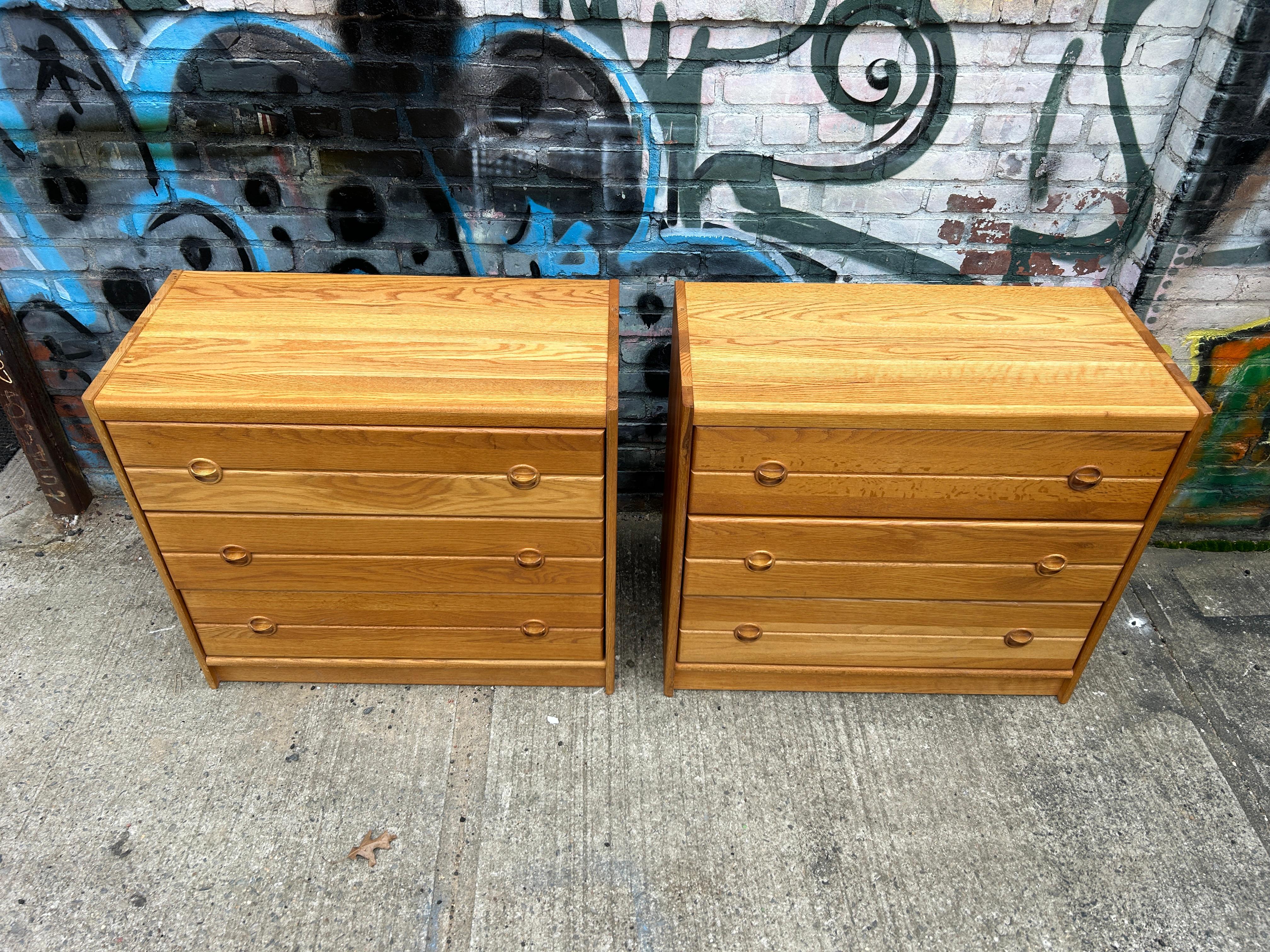 Beautiful pair of mid century Danish modern Solid Oak three-drawer dressers. Great simple design and great vintage condition - clean inside and out. Drawers slide smooth on metal glides. Great light blonde oak wood grain with solid oak round carved