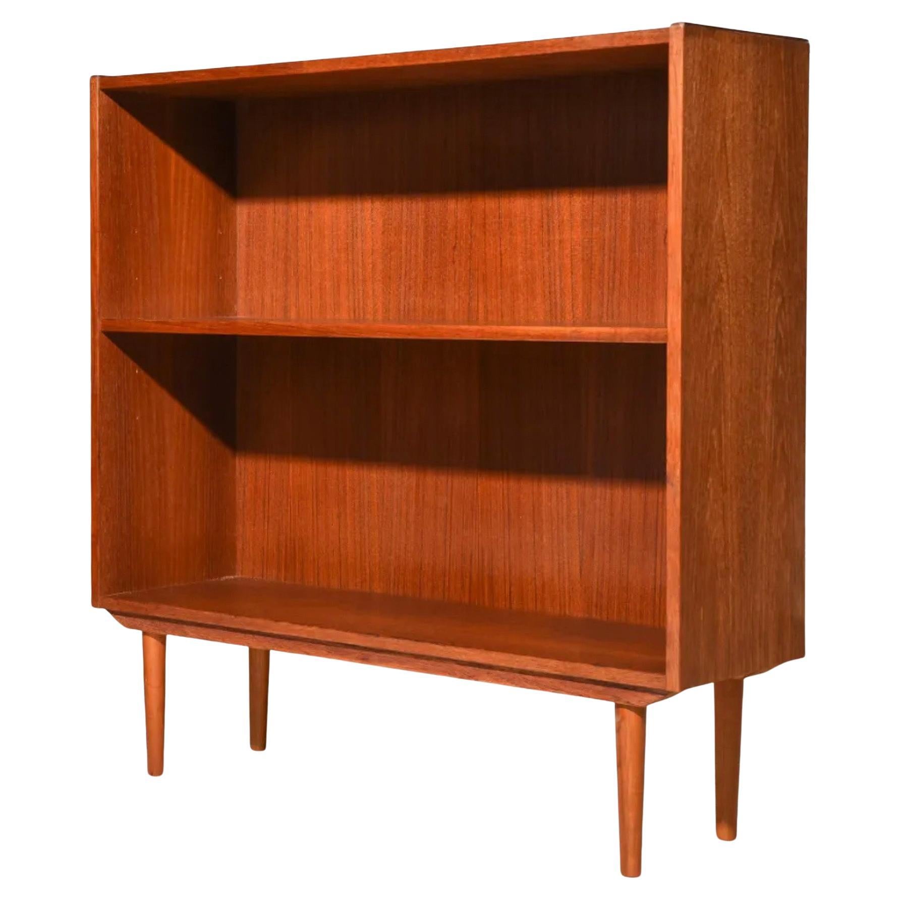 Pair of midcentury Danish modern teak bookcases. Each unit has 1 adjustable shelf in the middle. Nice reddish brown teak finish. Good vintage condition. Made in Denmark. Located in Brooklyn NYC.

Sold as a pair.

Each unit measures 34” W x 12” D