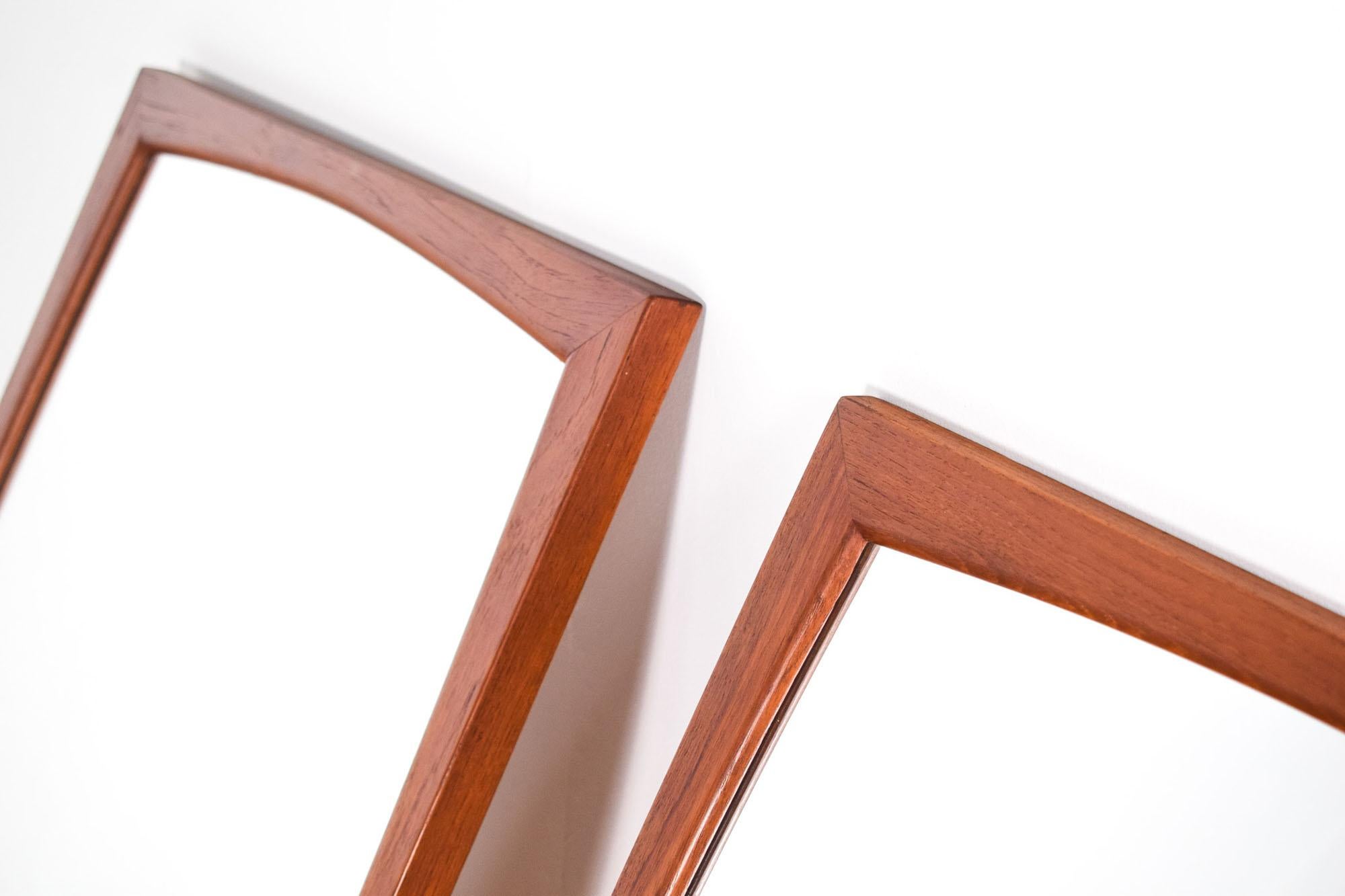 Mid Century pair of teak mirrors, a classic example of Scandinavian design, crafted by Aksel Kjersgaard and produced by his company, Aksel Kjersgaard Odder, in the 1960s in Denmark. These mirrors, identifiable as model No 10, carry the mark of their