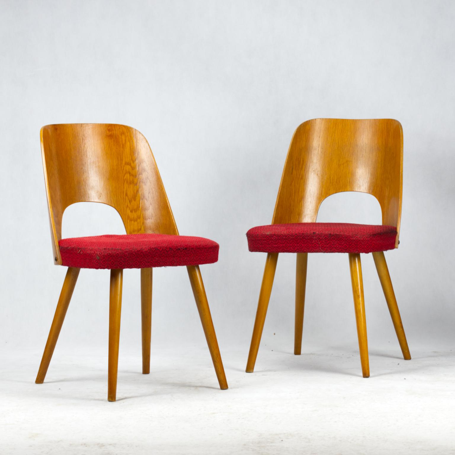 This set of two dining chairs was designed by Oswald Haerdtl for Thonet in 1955. The chairs are made of bent beech plywood formed structures and round tapered wooden legs.