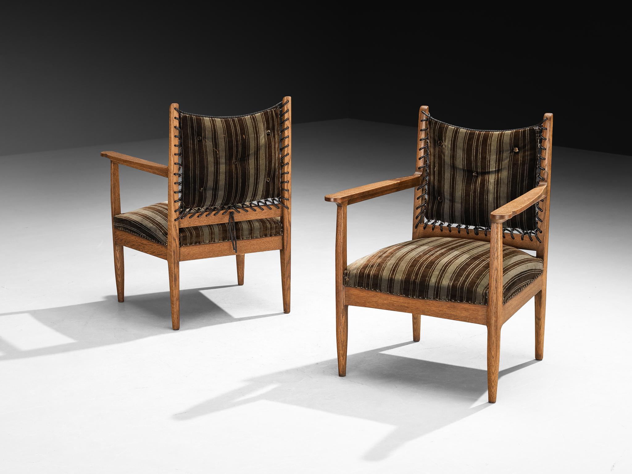 Pair of lounge chairs, oak, fabric, leather laces, the Netherlands, 1950s

These elegant lounge chairs are from the 1950s. The solid oak frames display clean, architectural lines, softened by subtly tapered legs and gently curved armrests that